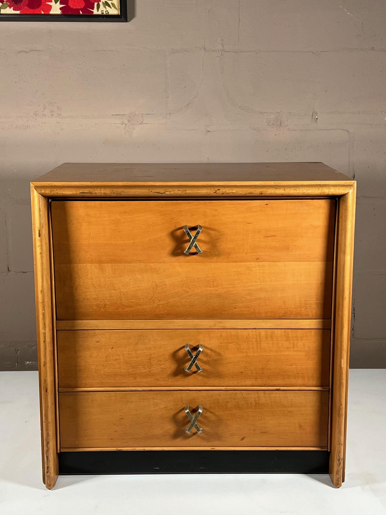 A classic nightstand designed by Paul Frankl for John Stuart, ca' 1950s. Nickeled X handles, drop down front with 2 drawers below. Original finish in good condition.