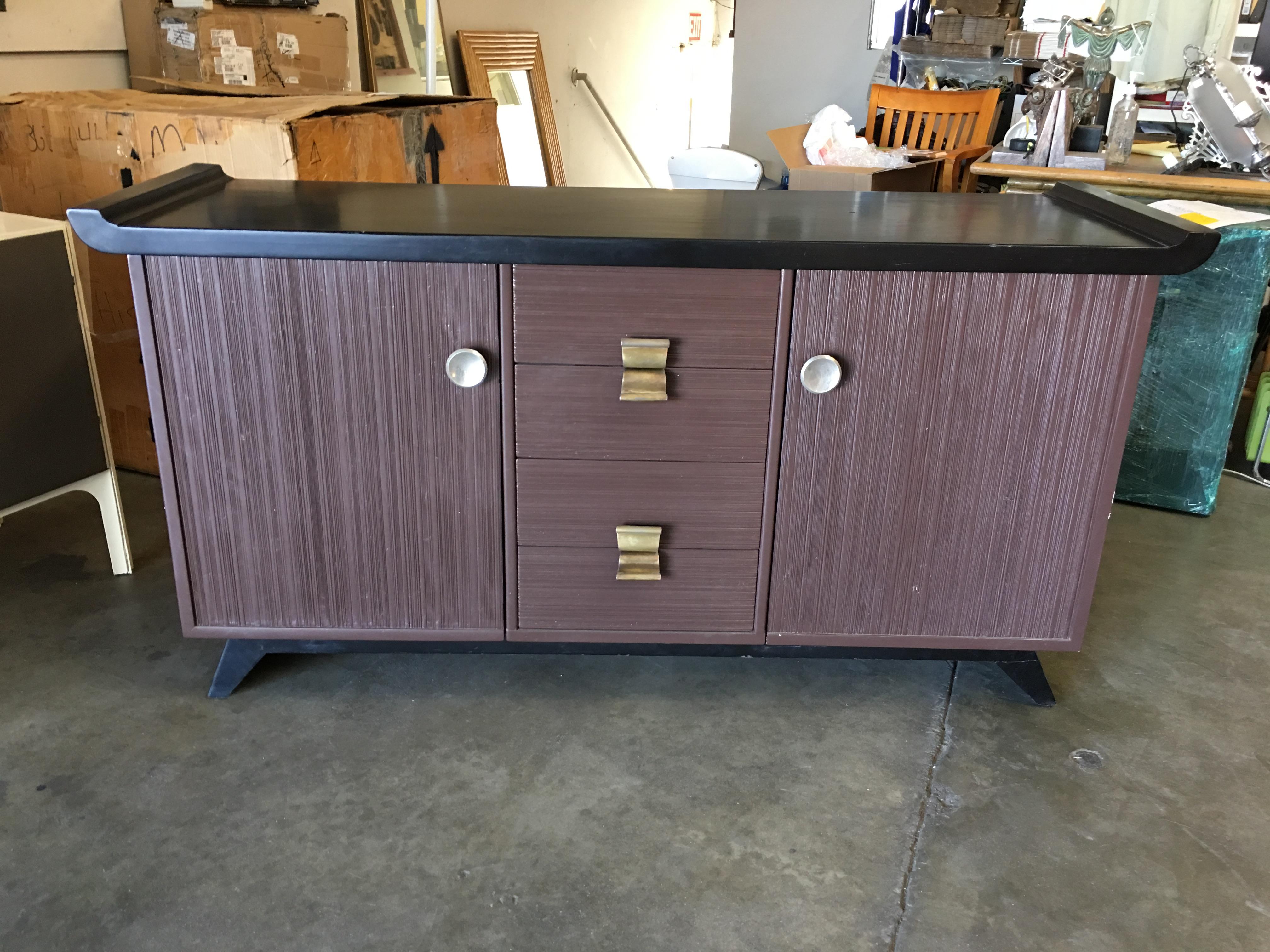 This Mid-Century Modern buffet or credenza by Paul Frankl for Brown Saltman Company features his trademark combed wood sides with black lacquer top.

It is branded beneath 