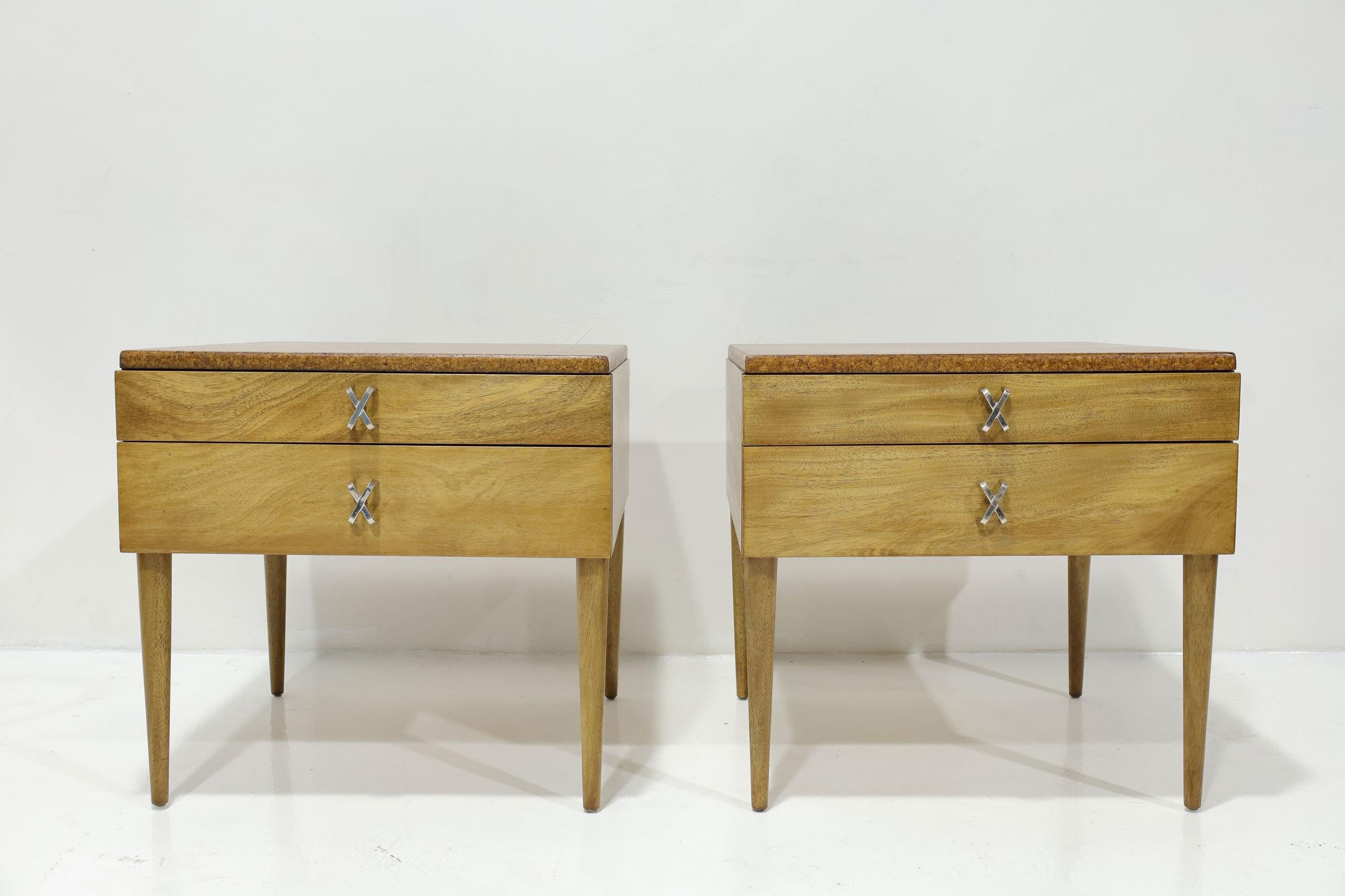 Superbe paire de tables de nuit en liège Paul Frankl par Johnson Furniture. Les tables de nuit comportent deux tiroirs chacune, un plateau en liège et des poignées croisées en laiton. 