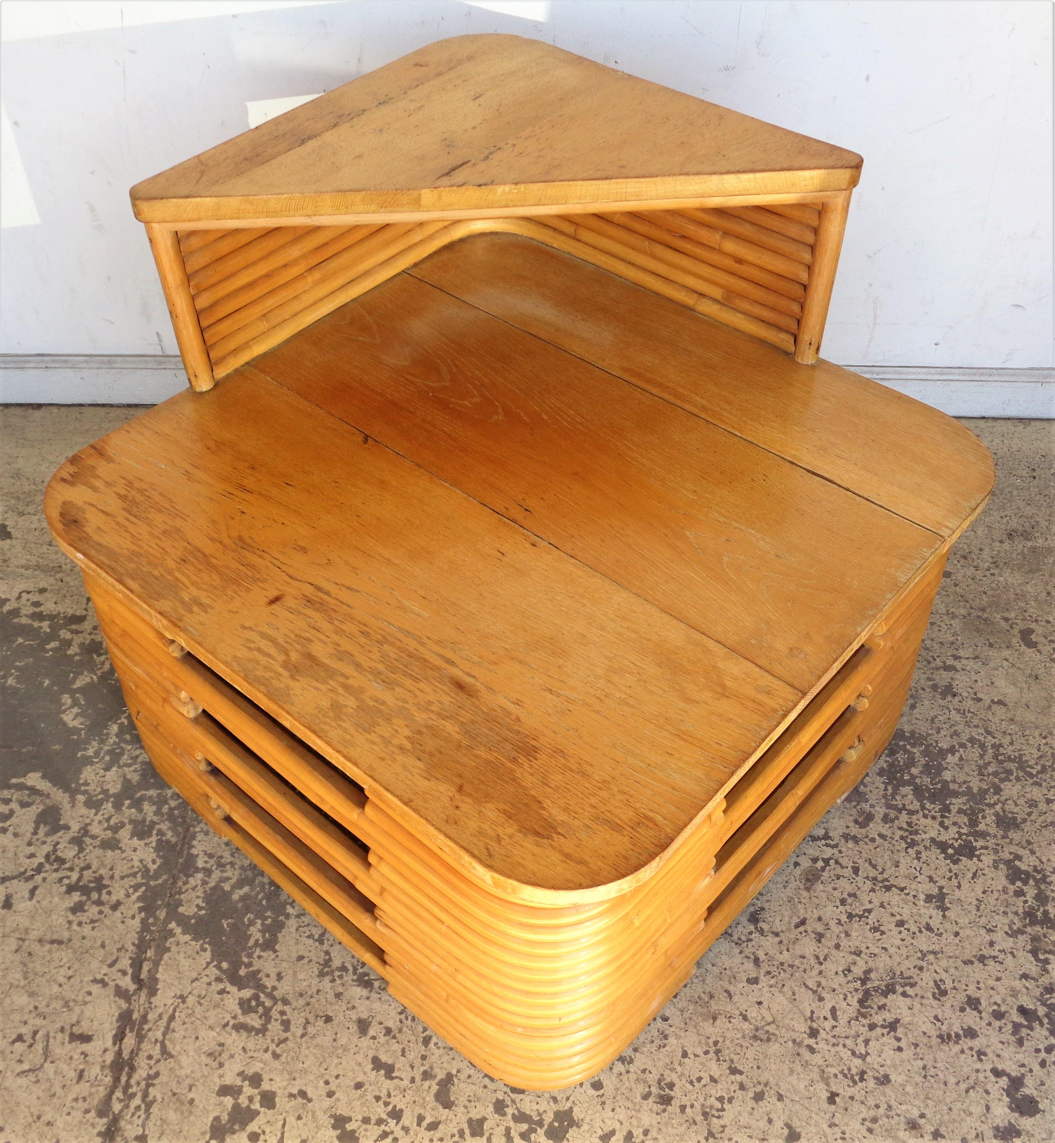 Table d'angle / table d'appoint empilée en rotin et chêne à deux niveaux ( peut être utilisée entre deux chaises ) en rotin couleur miel d'origine. Design/One de Paul Frankl, fabriqué au Japon. La hauteur de l'étage supérieur en chêne est de 25
