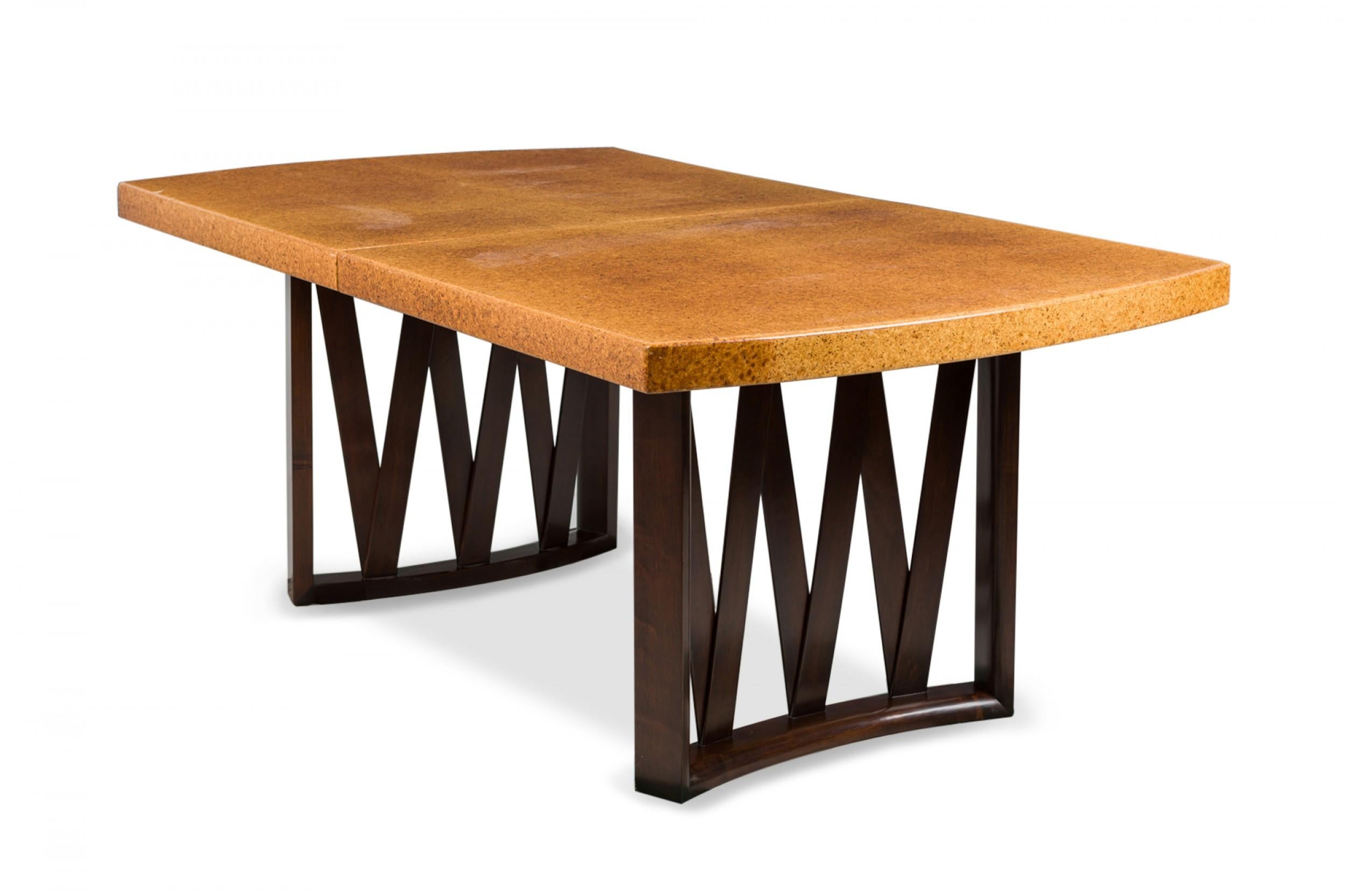 American mid-century dining / conference table with a rounded rectangular cork top with two removable leaves, resting on two dark-stained wooden legs with V-shaped central supports. (Paul Frankl for Johnson Furniture Company).