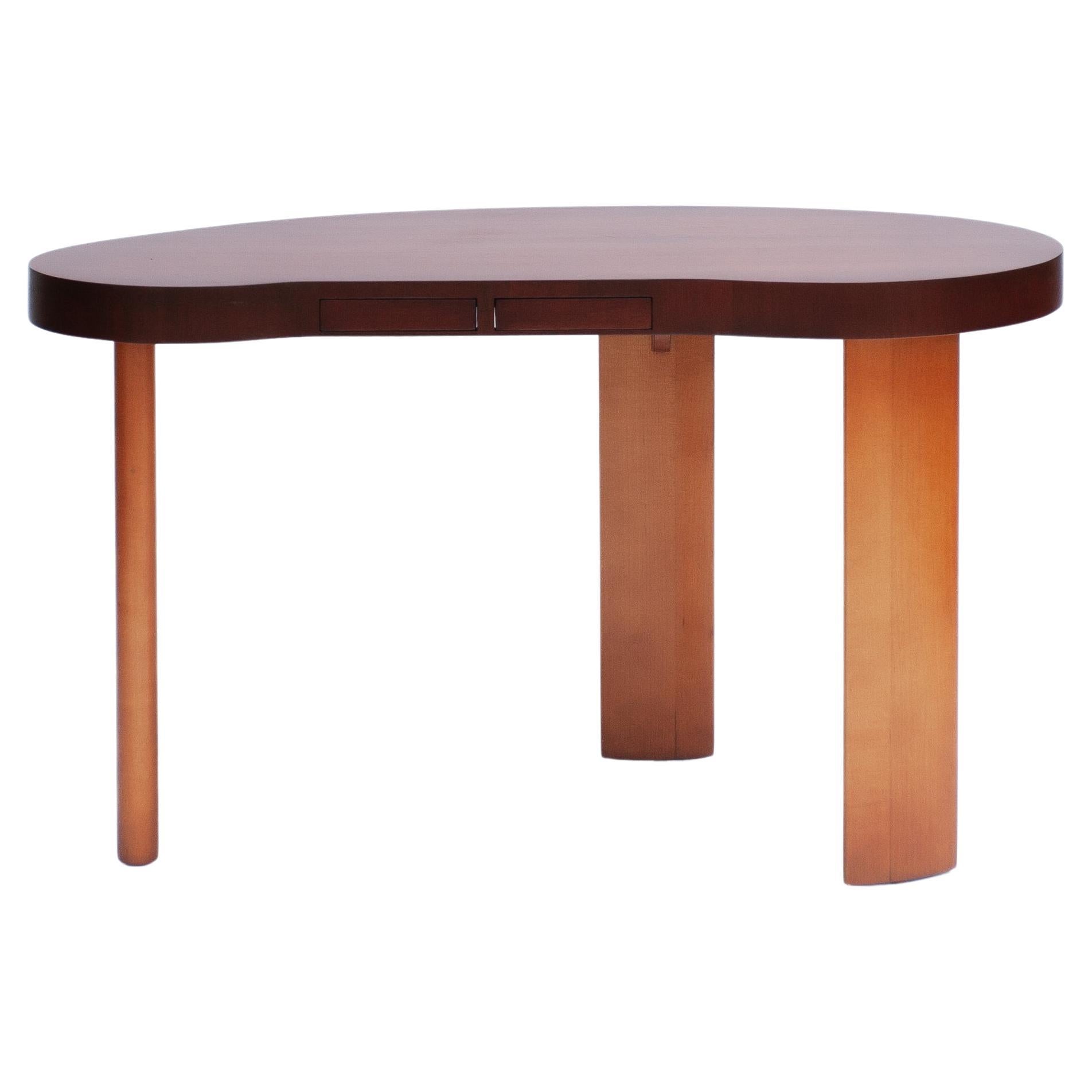 Paul Frankl, ein renommierter amerikanischer Designer des 20. Jahrhunderts, schuf in Collaboration mit der Johnson Furniture Company ein zeitloses Meisterwerk - einen nierenförmigen Schreibtisch, der Funktionalität und Raffinesse miteinander