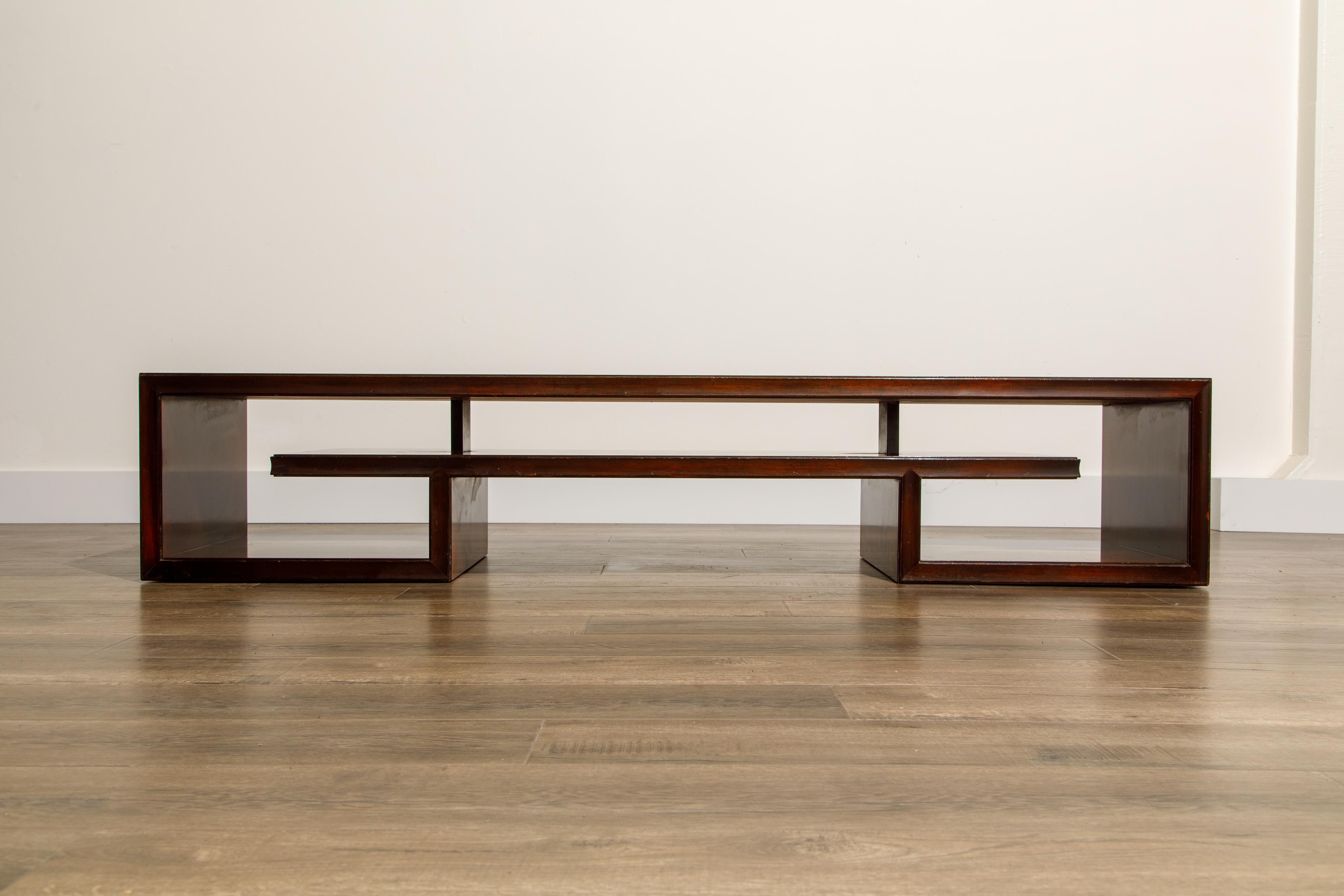 This long Rosewood coffee table by Paul Frankl for Johnson Furniture Co features a greek key form and a long slender size. This piece can work wonderfully as a coffee table and presents a unique solution to be used as a low console table or media