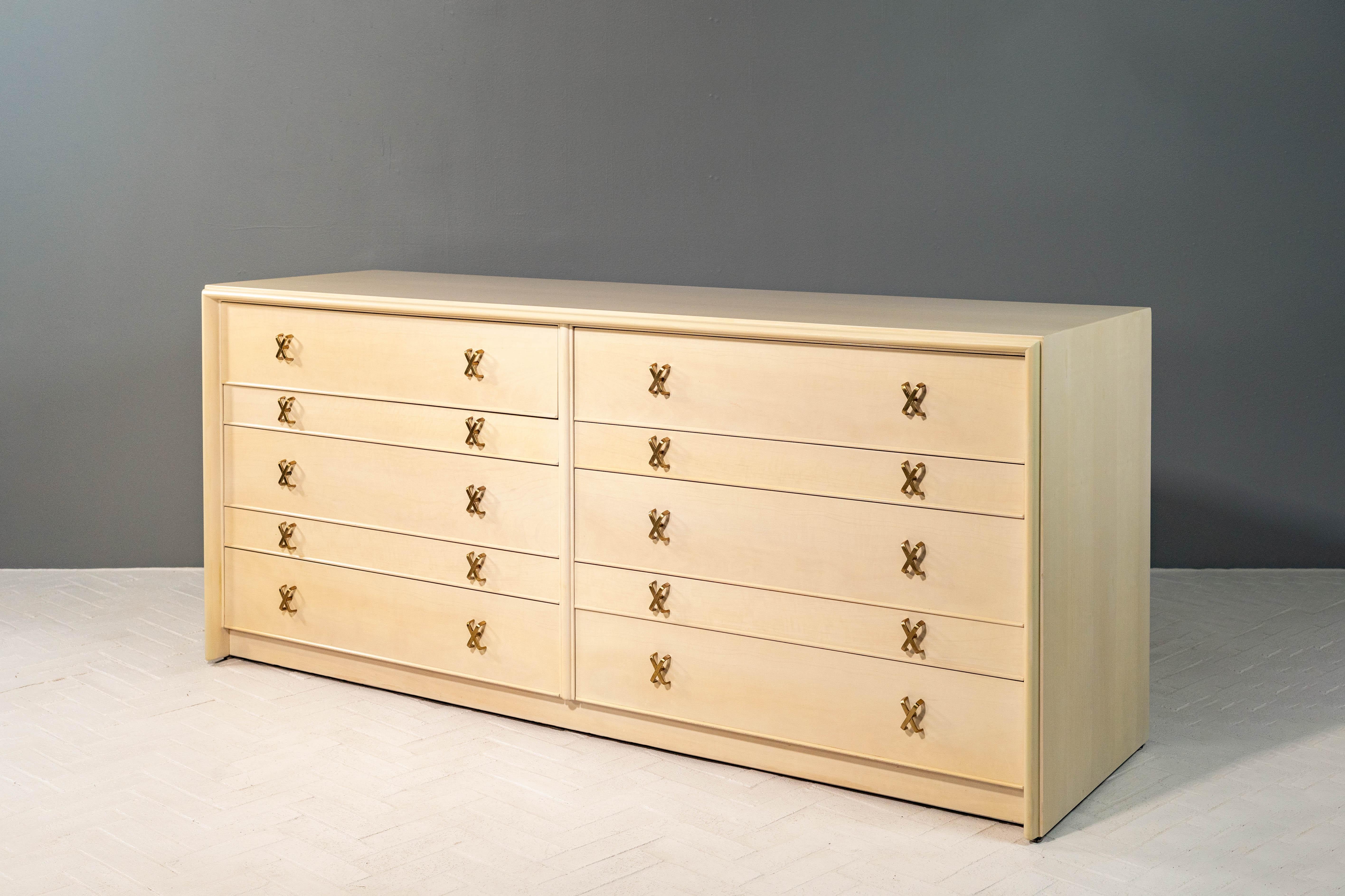 USA, circa anni '50. Un grande e versatile scrittoio di Paul Frankl per Johnson Furniture. Presenta un'imponente struttura in acero con dieci generosi cassetti di dimensioni sfalsate. Le maniglie a forma di x in ottone lucido e il bordo anteriore