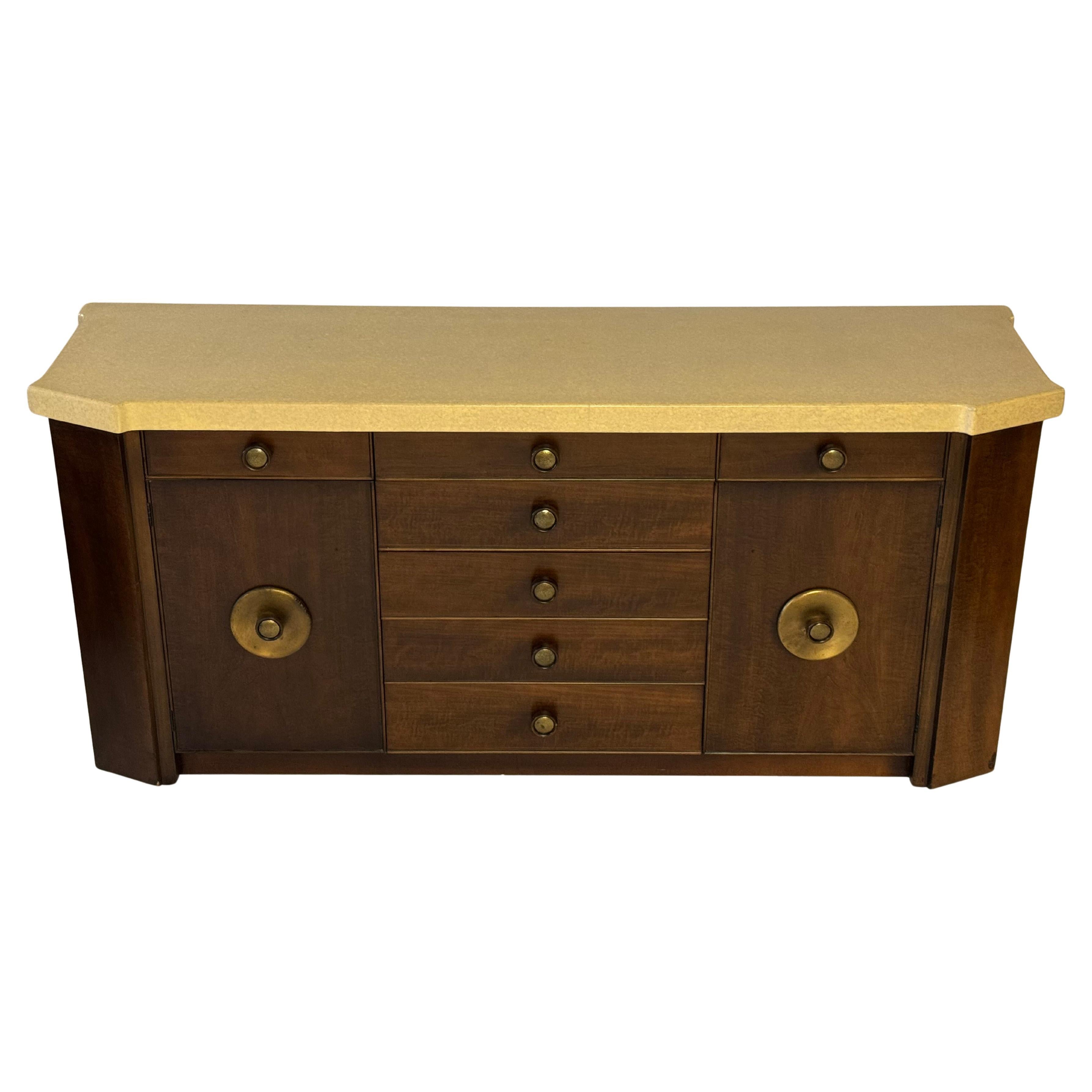 Mid-Century Modern Paul Frankl for Johnson Furniture Co., elegant handsome mahogany sideboard with a lacquered creme tone thick cork top with round hammered brass knobs.  Five center drawers flanked by two divided top drawers having lower cabinets
