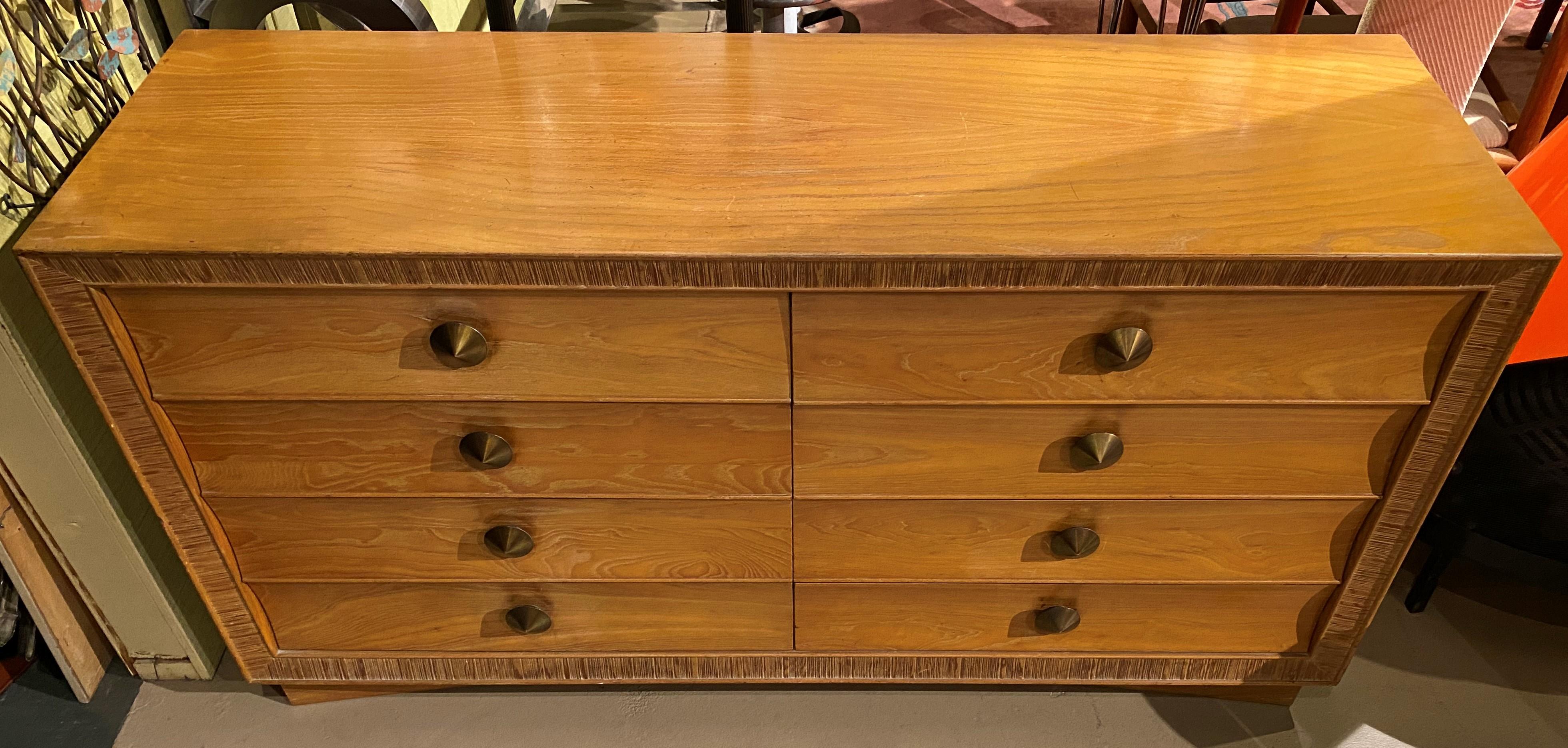 A splendid mid century eight-drawer oak dresser or chest of drawers created by Austrian designer Paul Frankl (1886-1958), well known for his Art Deco and “skyscraper” furniture. This combed oak bordered dresser features bold pulls and a nicely