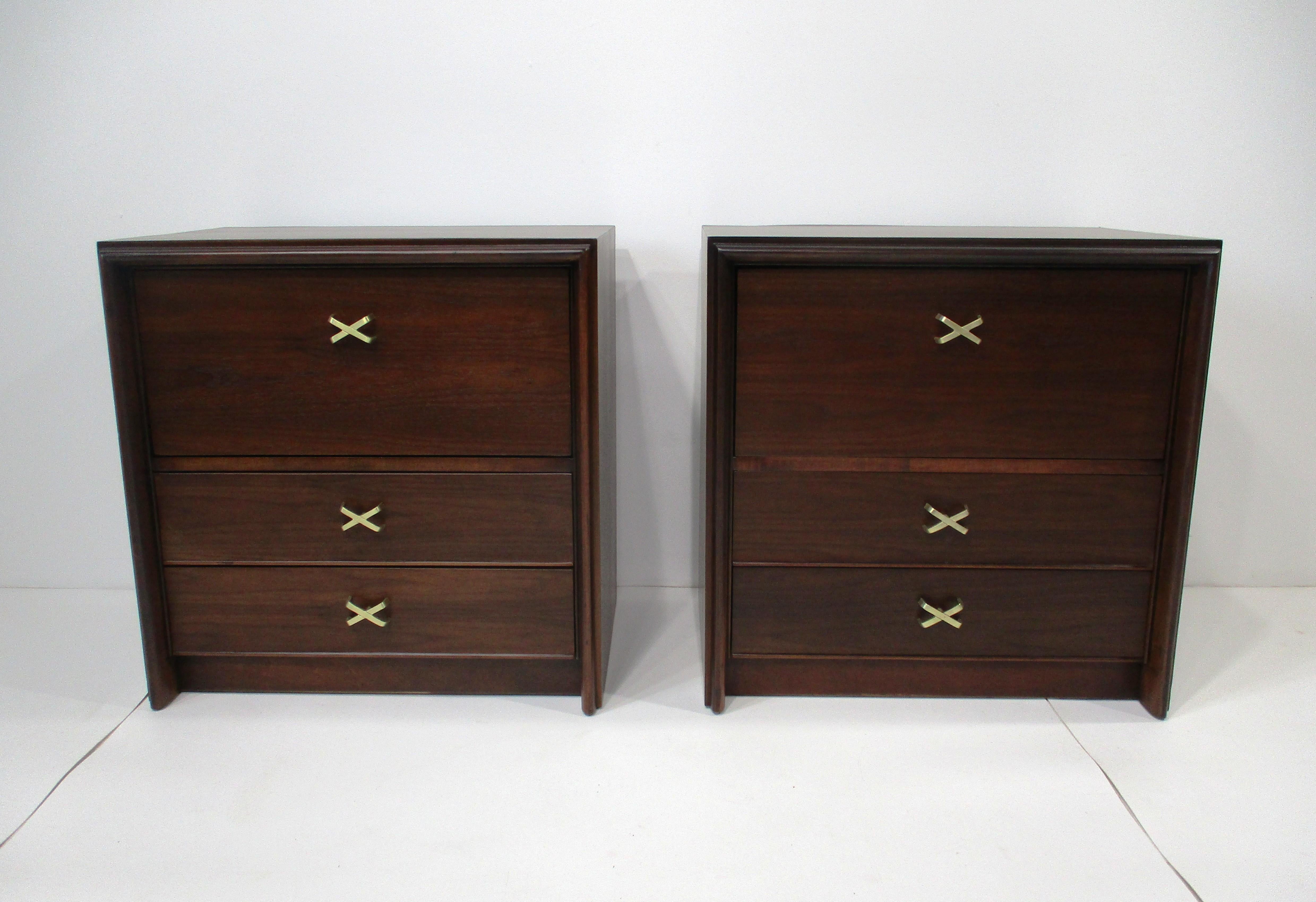 A pair of exceptionally stunning nightstands with two lower drawers and a functional pull down door with storage to the top . Cast solid brass X pulls give the pieces a rich look mixing with the darker toned wood finish makes these a superb quality