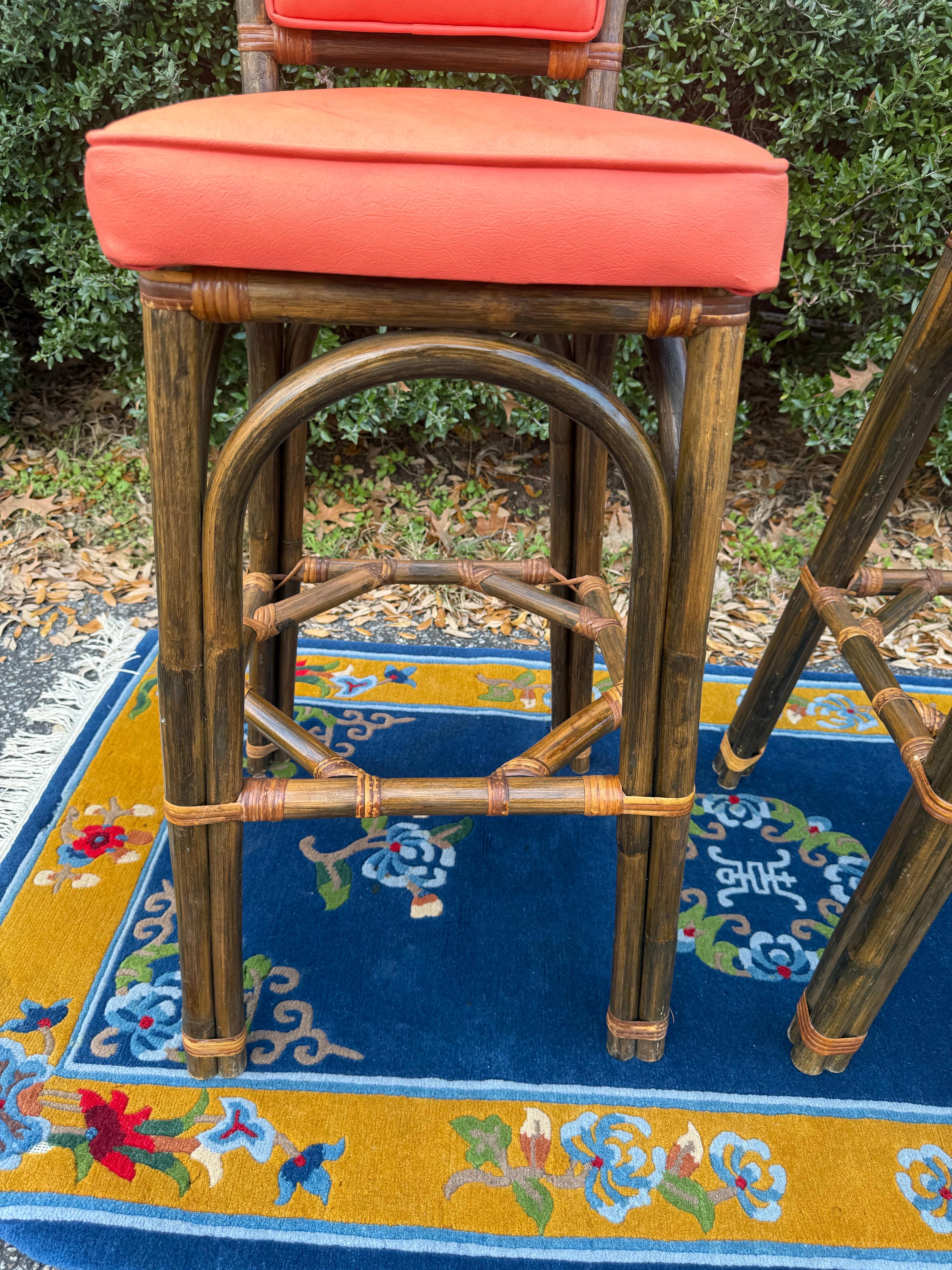 These barstools are different from any pair I’ve had to date.    They are very sturdy and made of bent bamboo wrapped with rattan.  They have an octagonal shaped stretcher on the inside of the legs.  They have a bright orange faux leather