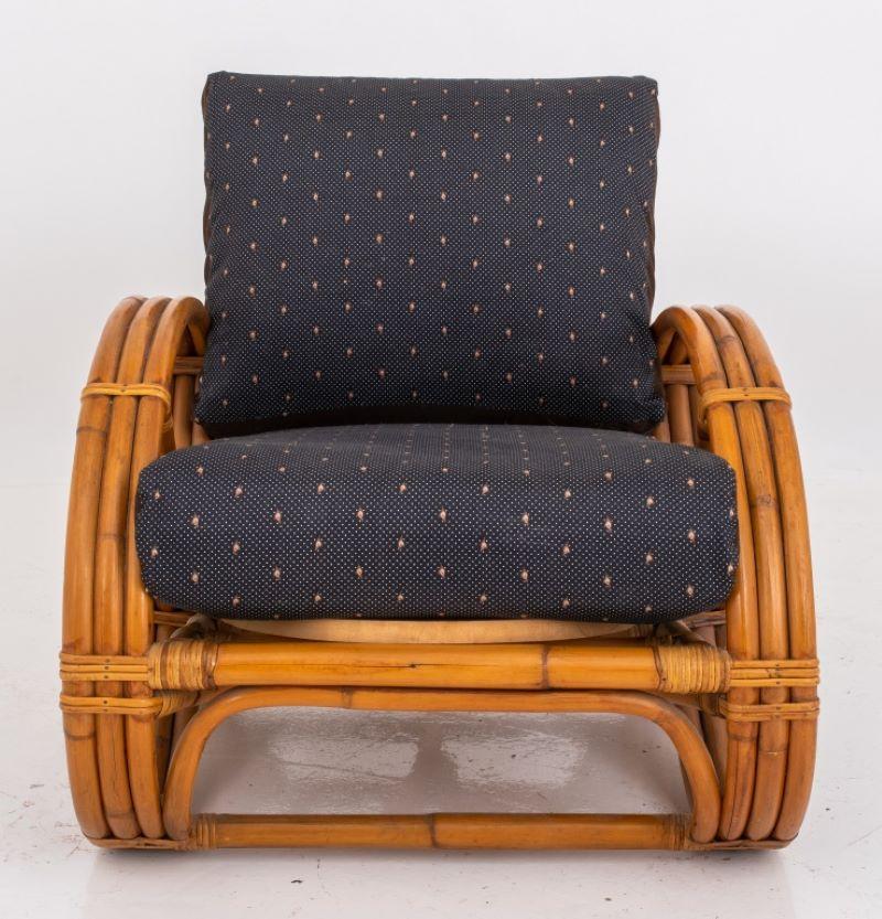 Bamboo pretzel-arm lounge chair in the manner of Paul Frankl, with pretzel-shaped bent-bamboo arms and with upholstered back and seat cushions. Measures: 31
