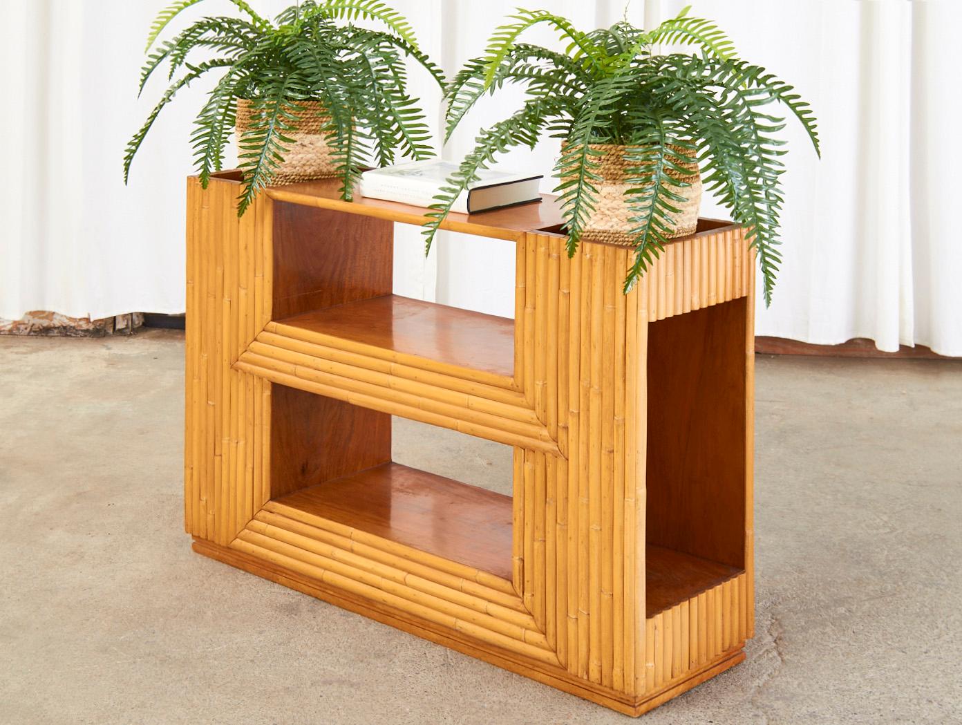 Gorgeous Mid-Century Modern three tier bookcase or plant Stand attributed to Paul Frankl. The case features a radiant grained mahogany frame veneered with split bamboo rattan and finished on all sides. Amazing attention to detail with an open niche