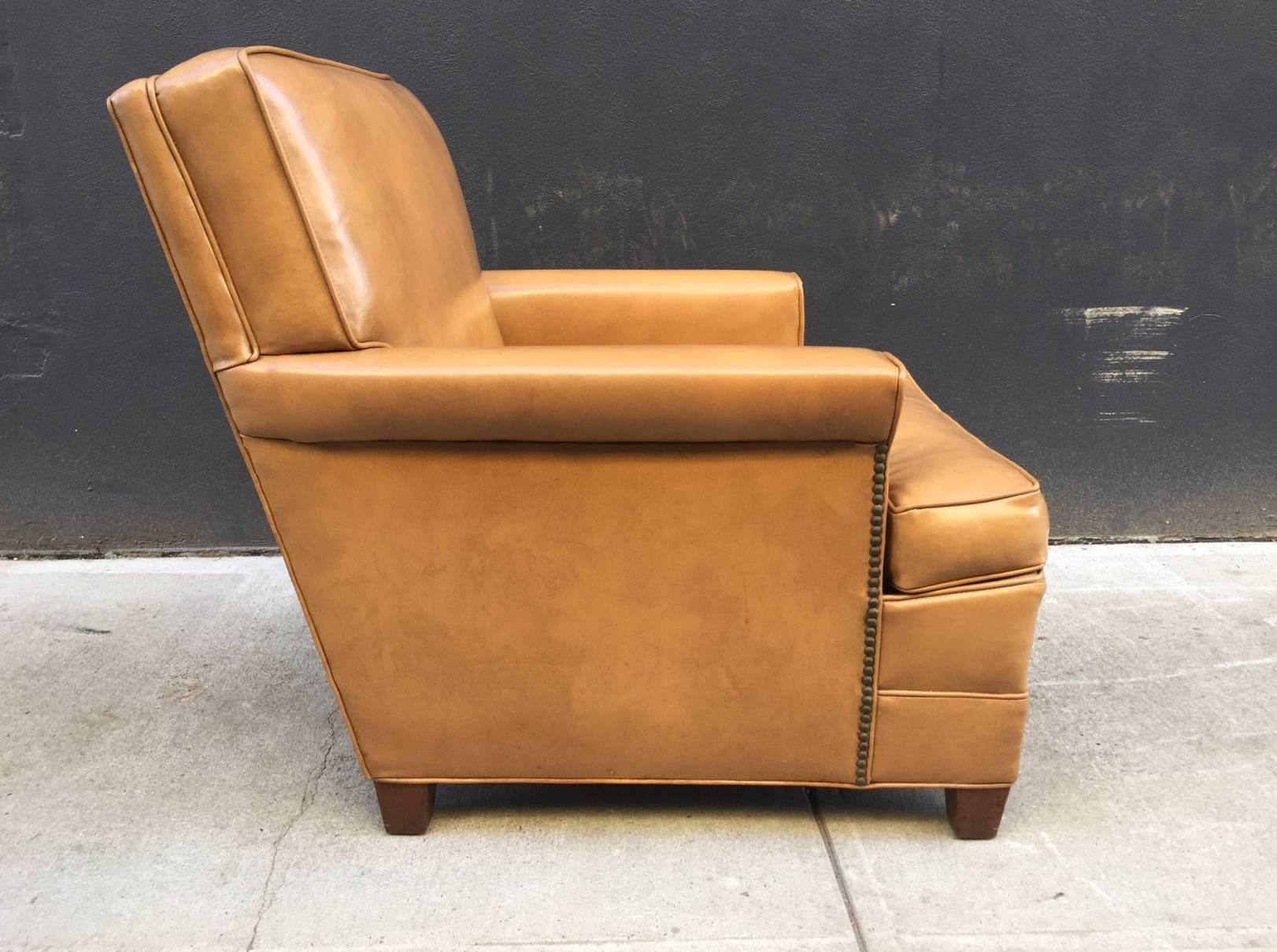 Pair of Paul Frankl lounge chairs. Chairs have vinyl upholstery, solid walnut legs and brass tacks to the trim. Art Deco.