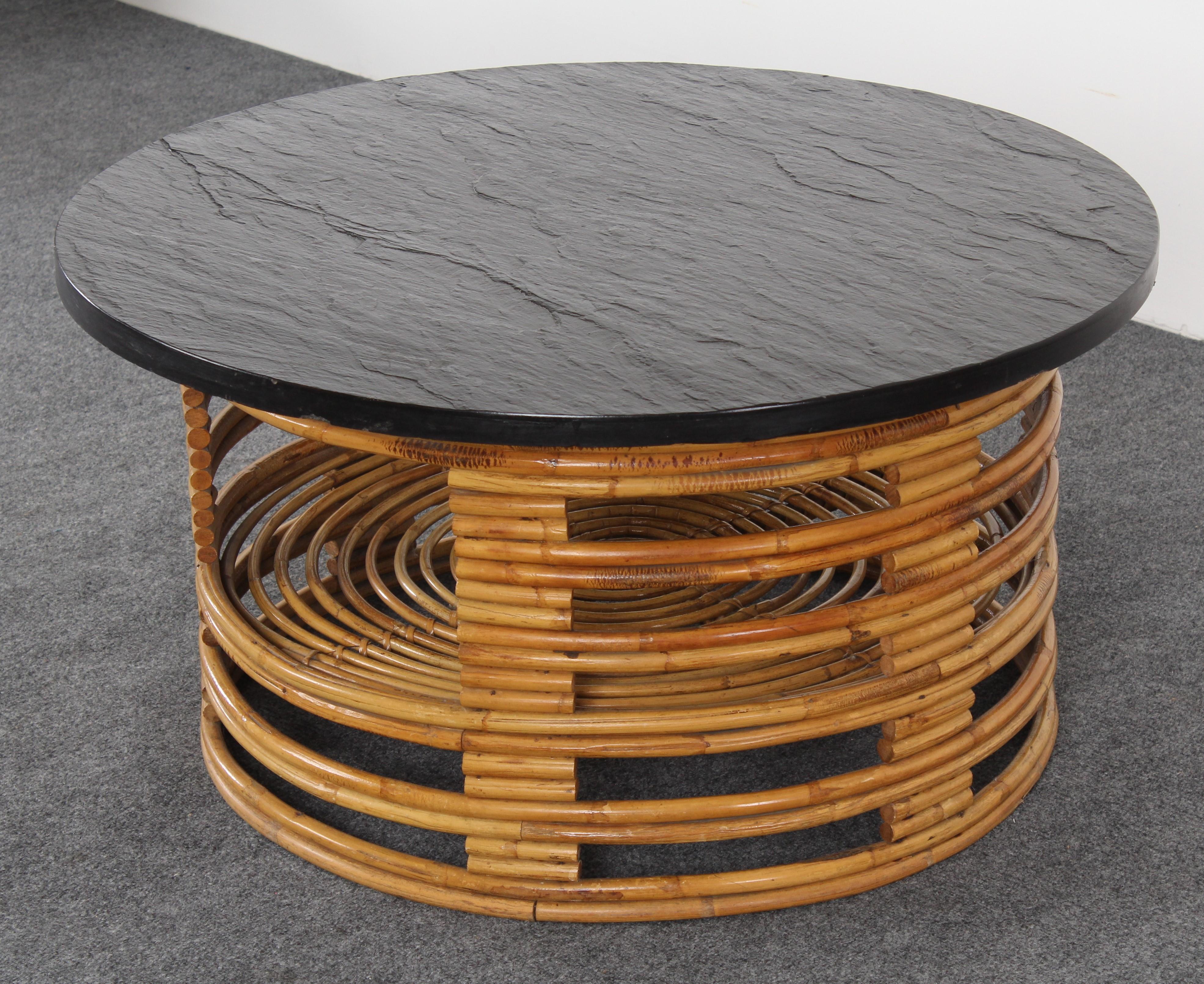 A Paul Frankl Style round bamboo rattan coffee table with slate top, 1950s. Good condition with age appropriate wear.

 