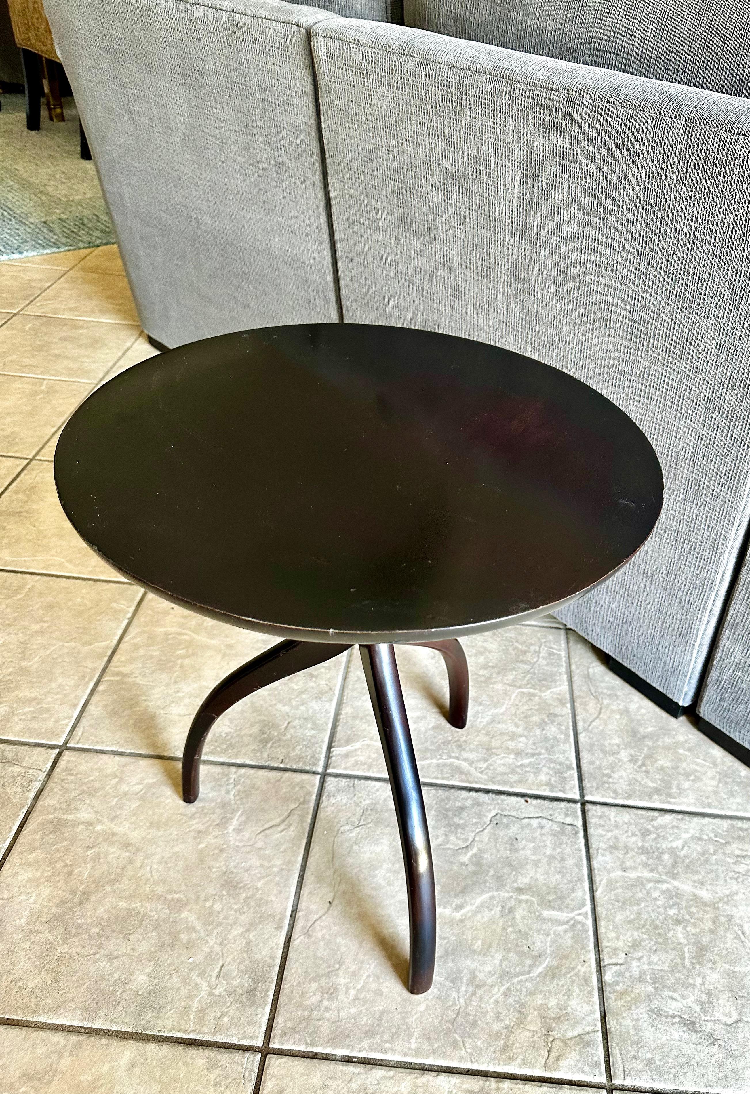 Single round top dark walnut/espresso finish wood side or end table. Solid wood construction table resting on gently curved tripod legs. 