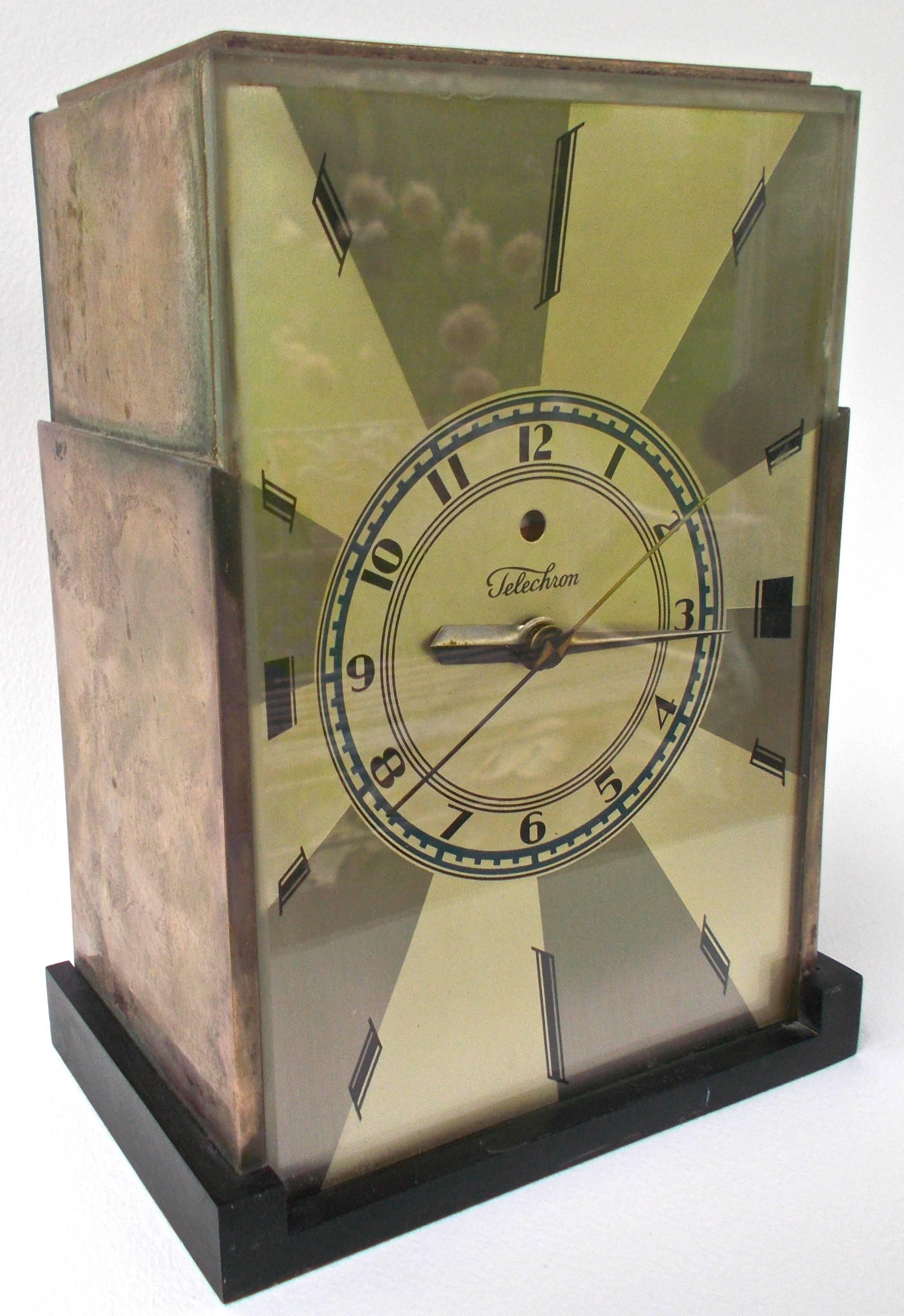 The iconic American Deco Frankl 'Skyscraper' mantel clock. Polished silver over brass with black bakelite base. This rare 'top of line' deco item retains the original bevelled glass front and the rare blue-green face. Illustrated in numerous period