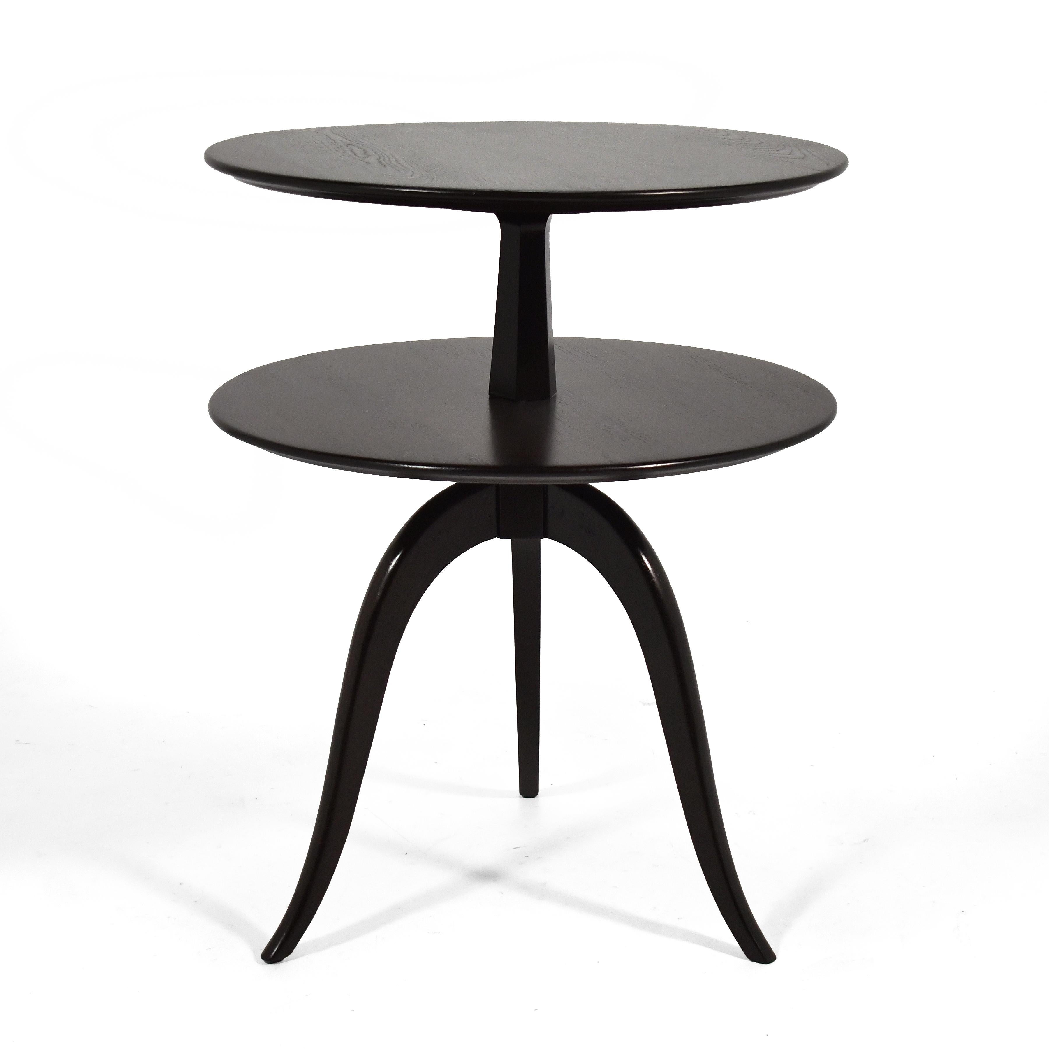 This elegant design by Paul Frankl for Brown-Saltman has many uses. The three gracefully curved and tapered legs support a pair of round tops and the form, shape and scale allow it to serve as a side table, an end table, nightstand, lamp table, or