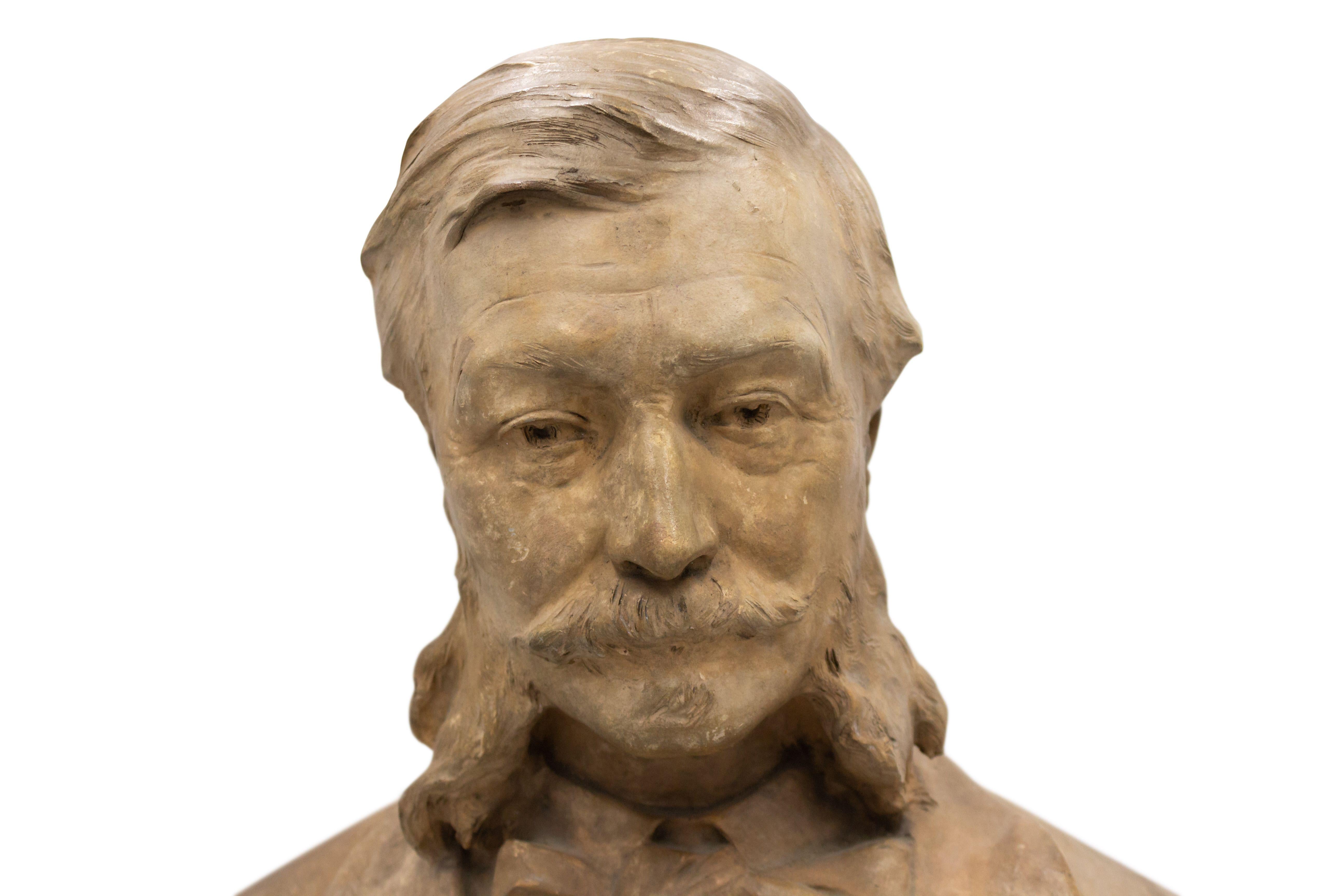French Victorian terra-cotta bust of gentleman with large sideburns and mustache wearing a suite and bow tie supported on a square pedestal base (signed: P. GASQ 96).
 