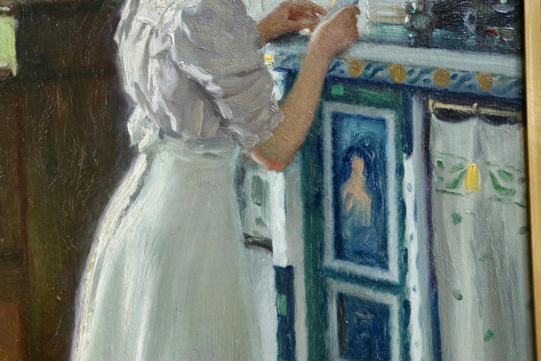 Oil on panel by Danish painter Paul Gustave Fischer depicting an elegant young woman, Harriet, in an interior reading a letter. There is a piano in the corner of the room and framed pictures adorn the walls. Harriet was the artists daughter and he