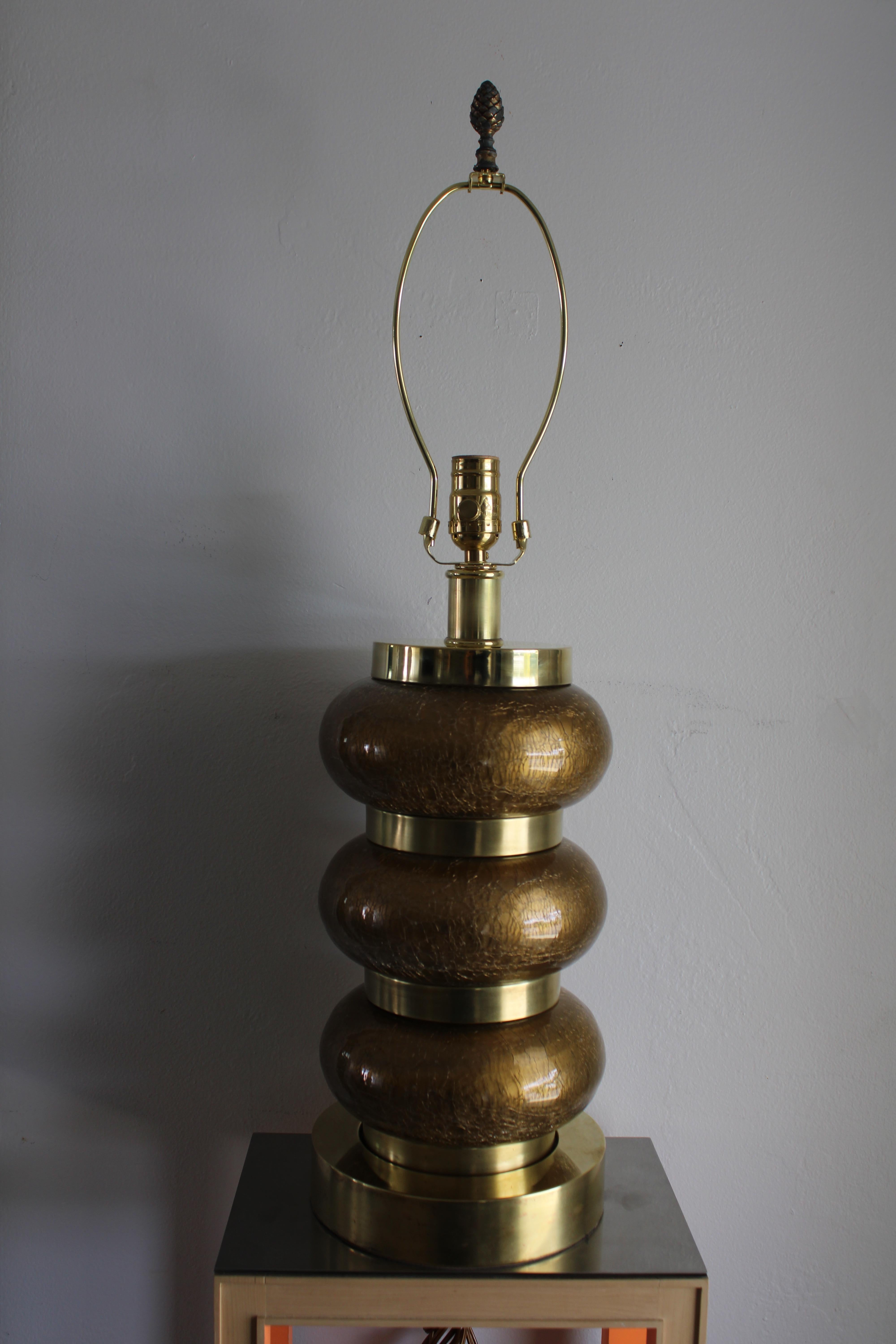 Reverse gilt and brass table lamp by the Paul Hanson Co. It consists of three alternating bands of gilt crackle glass ovals and patinated brass rings. Lamp measures 17