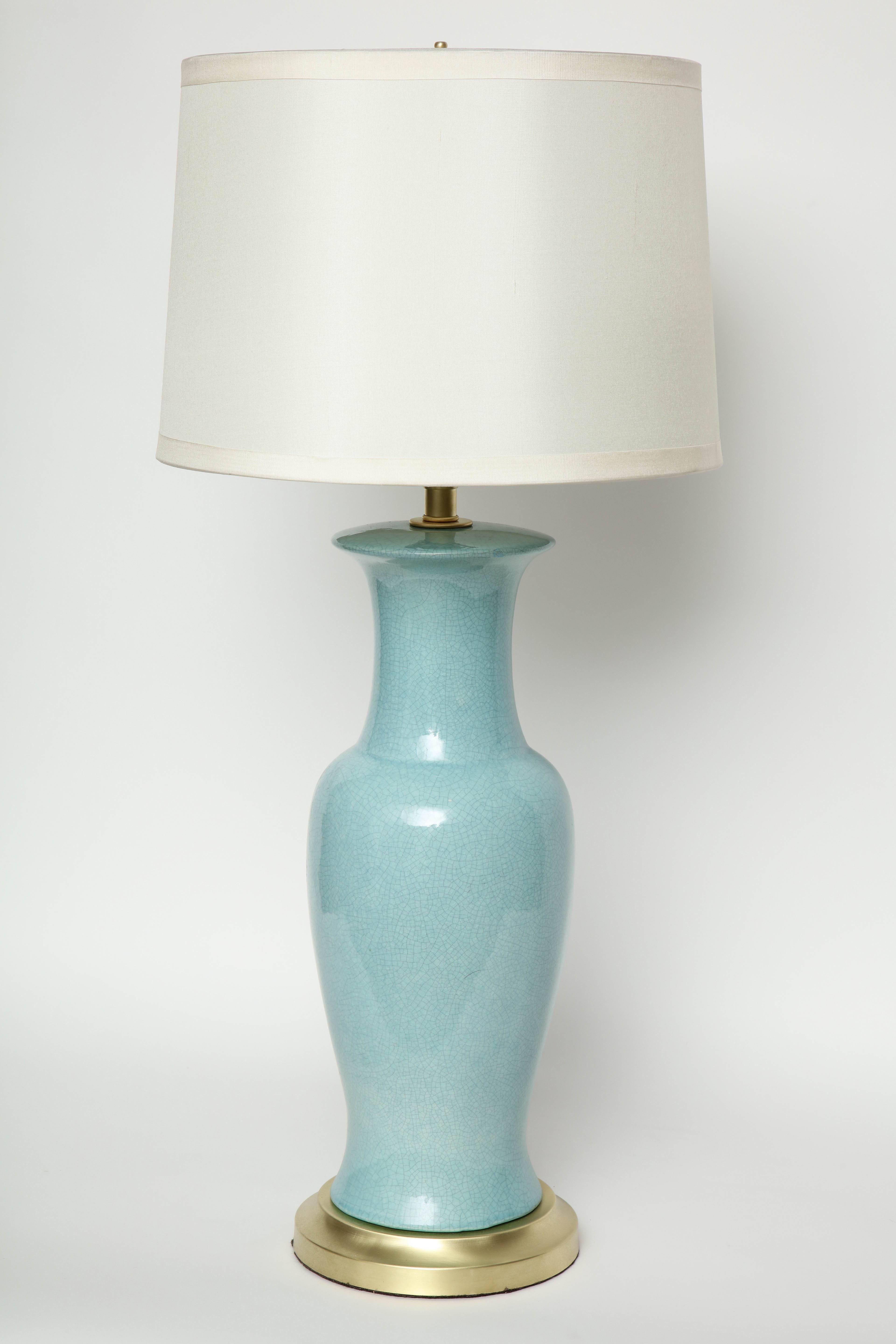 Pair of classically styled midcentury porcelain lamps in a fresh Robin's egg blue glaze with a crackled finish on satin brass bases. Rewired for use in the USA, 100W max.