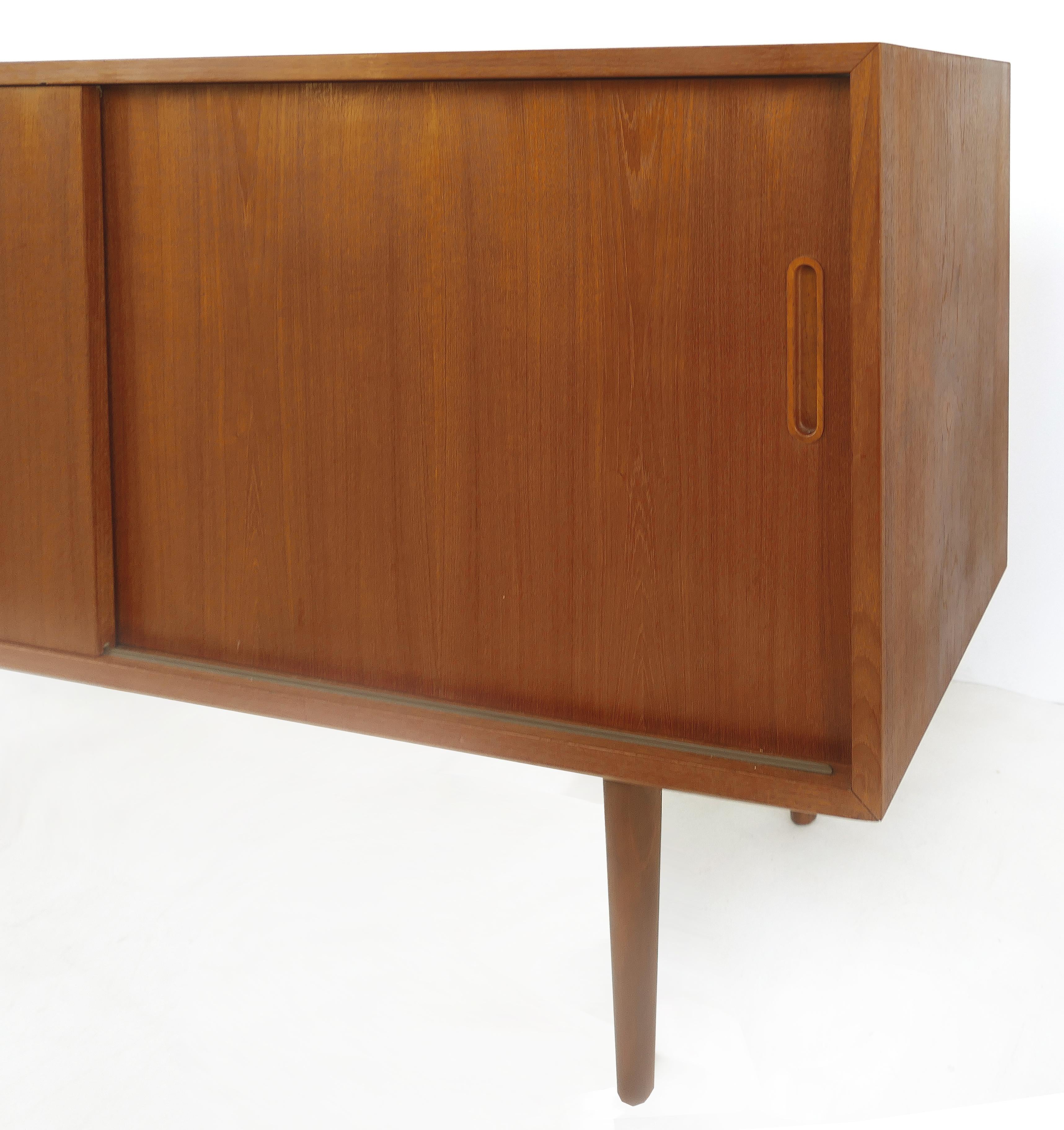 Paul Hundevad petite teak credenza server cabinet


Offered for sale is a small teak Danish modern server cabinet by Poul Hundevad of Sweden. The cabinet has sliding doors that open to reveal open shelves with a slender felt-lined drawer on the