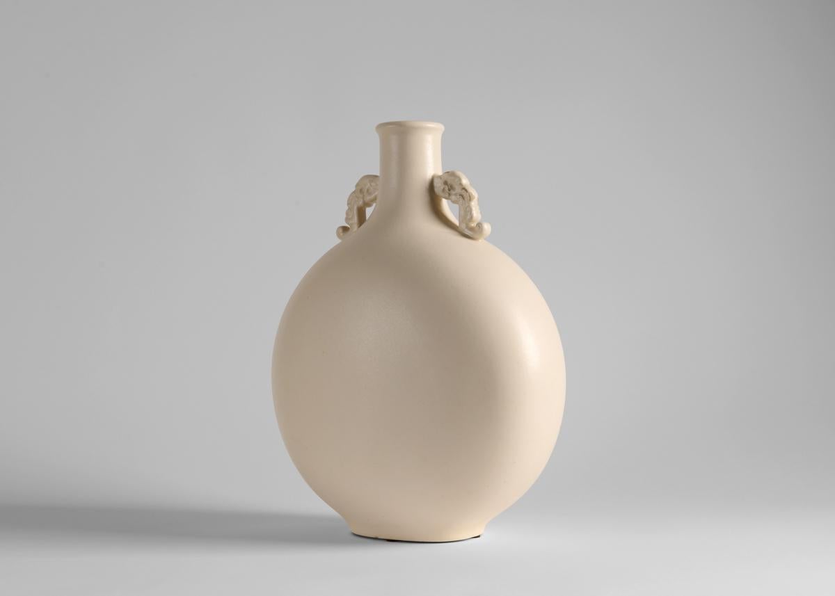 Classical in shape this cream glazed flask has a narrow neck with a pair of diminutive garland handles.Produced by Manufacture Nationale de Sèvres. Stamped: PM / SÈVRES