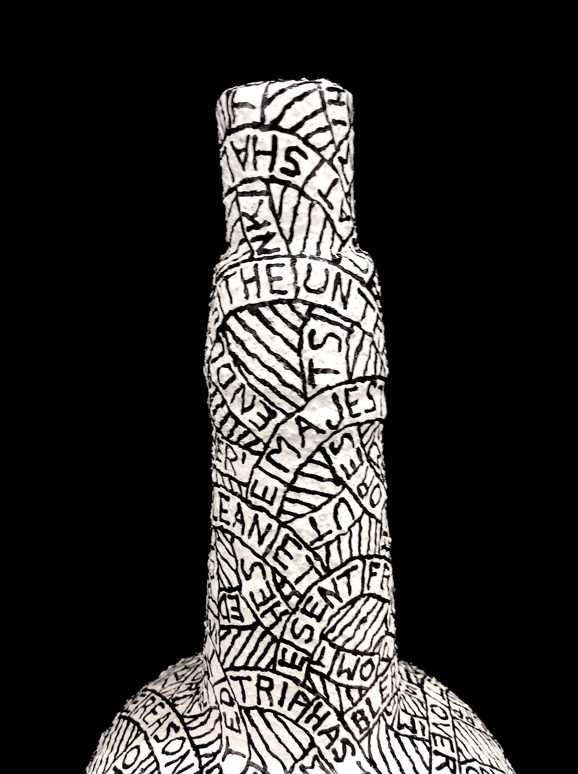Plaster, sand, & paint on found object
12 x 4 x 4 inches

This black and white sculpture was created by Hudson Valley-based artist Paul Katz, whose process involves coating found objects in plaster, sand, & paint. The inscription which coats the