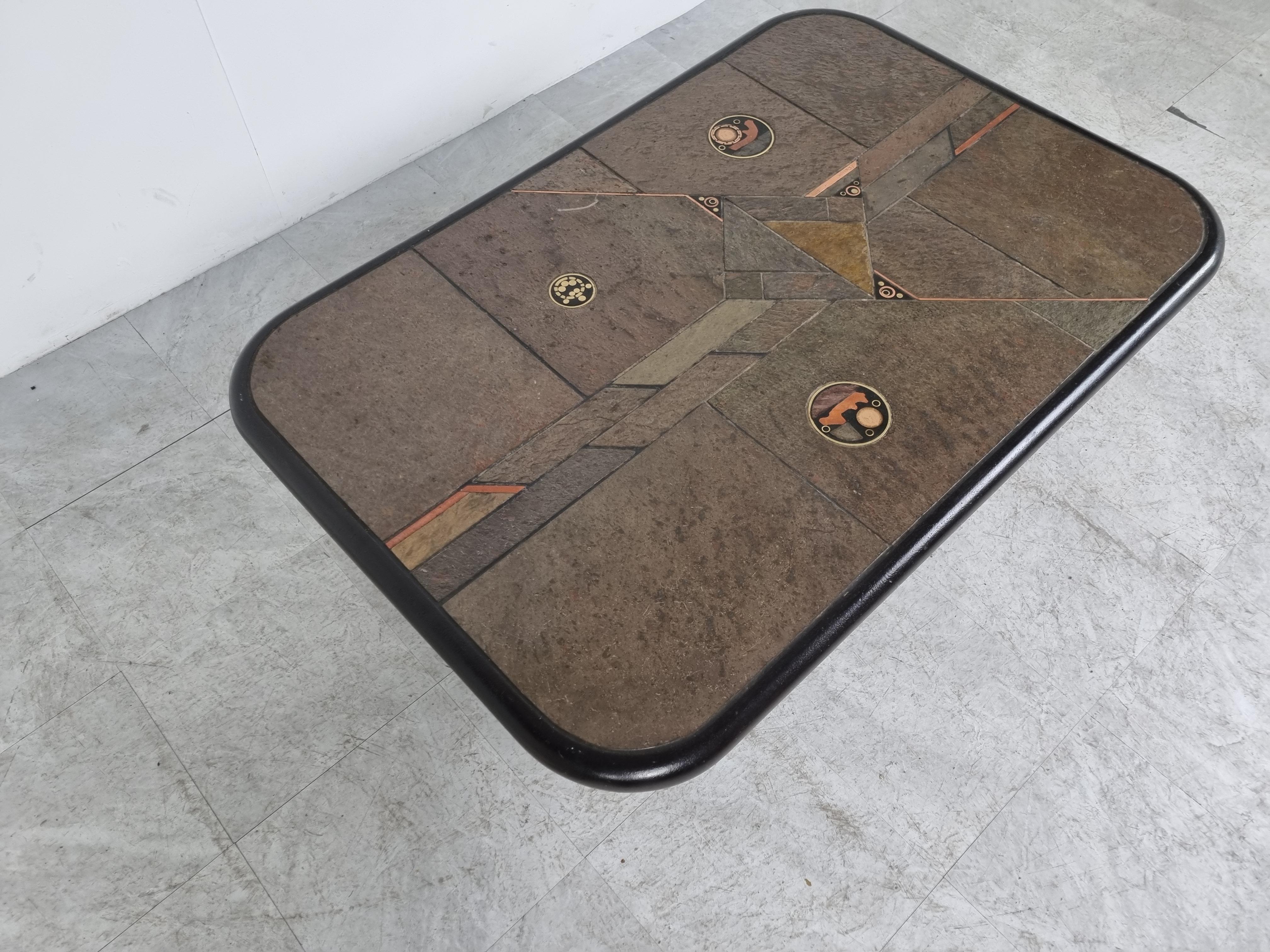 Brutalist slate and natural stone top coffee table with inlaid copper and brass.

Black wooden base.

The table is signed but we cant see by who.

Good condition.

Very much in the style of Paul Kingma.

1980s - Germany

Height: 46cm/18.11