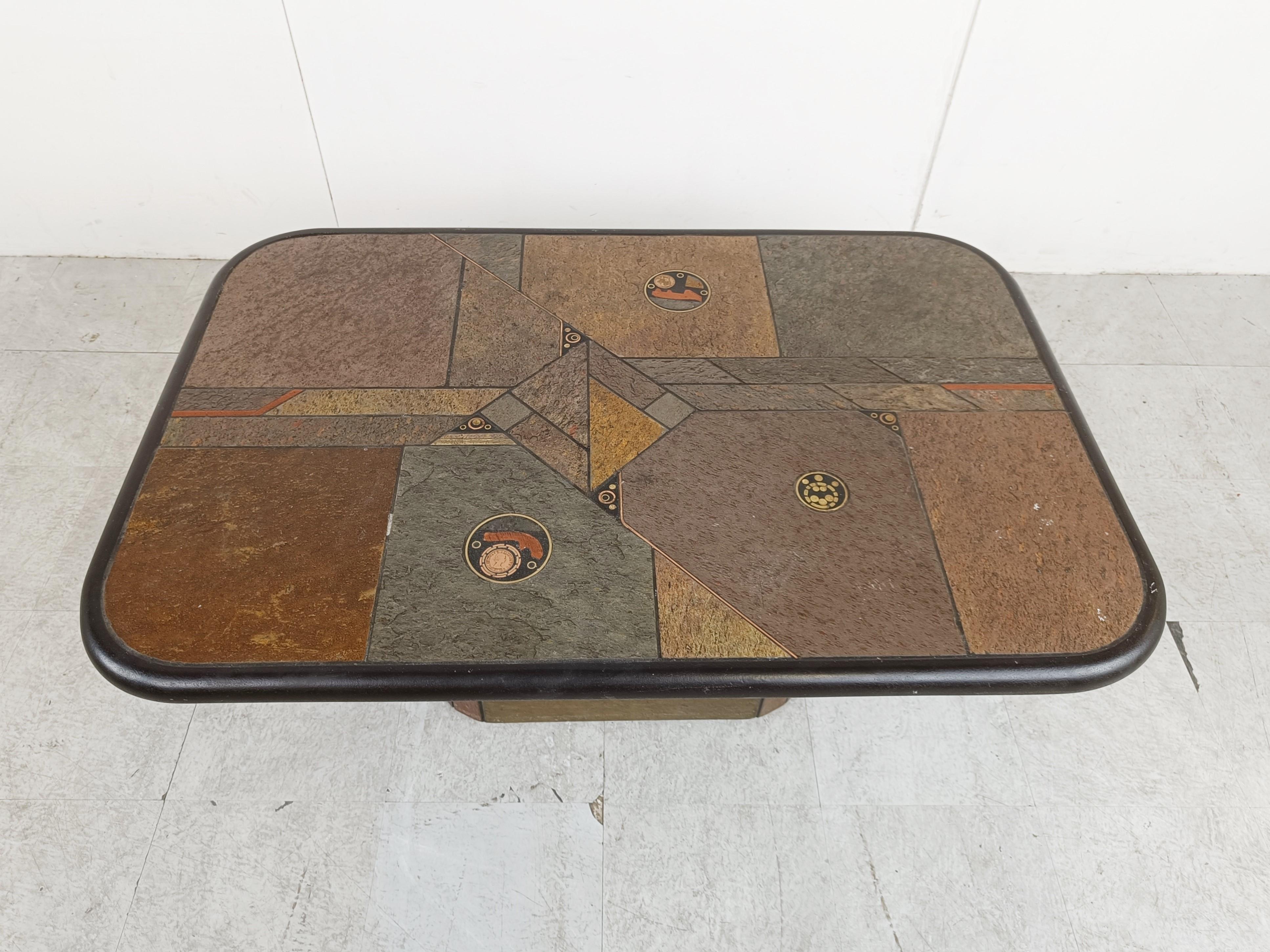 Brutalist slate and natural stone top coffee table with inlaid copper and brass.

The table is signed.

Good condition.

Very much in the style of Paul Kingma.

the table has little casters under the base to move around easily.

1980s -