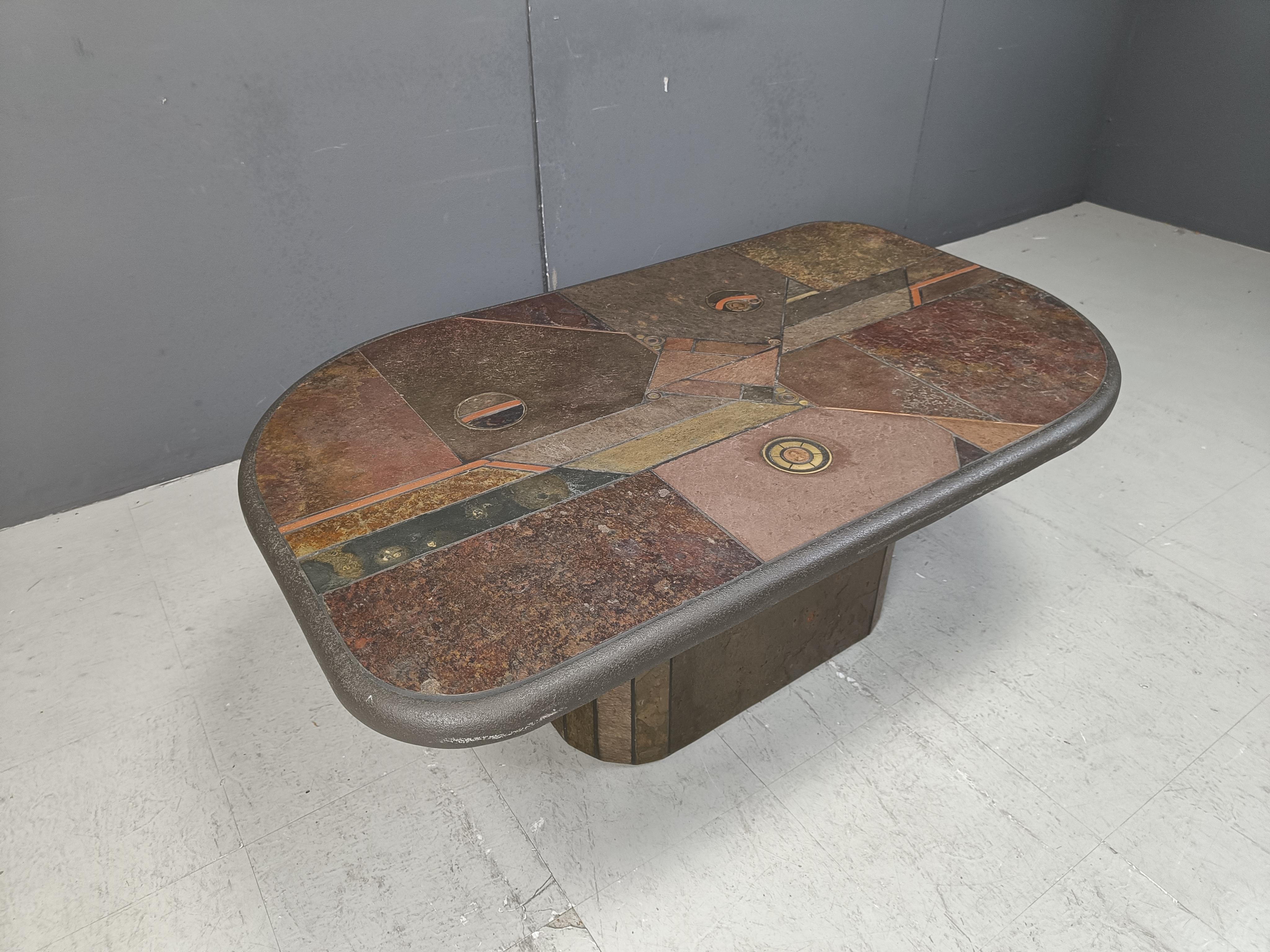 Brutalist slate and natural stone top coffee table with inlaid copper and brass.

The table is signed.

Good condition.

Very much in the style of Paul Kingma.

1980s - Germany

Height: 46cm
Width: 125cm
Depth: 75cm

Ref.: 25010204