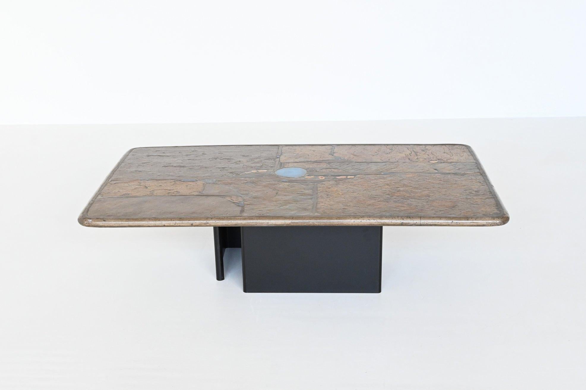 Beautiful rectangle shaped coffee table designed and made by Paul Kingma, The Netherlands 1995. The brown colored heavy and thick concrete top rests on two metal bases that are black lacquered. Beautiful composition of agate, slate, stones, copper