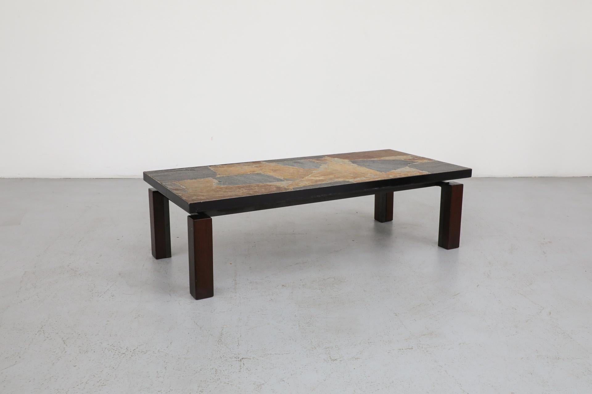 Paul Kingma inspired mixed slate and stone coffee table with wood and metal base. An inspired design, the metal framed heavy top appears to hover over the Brutalist base. In original condition with visible wear consistent with its age and use.