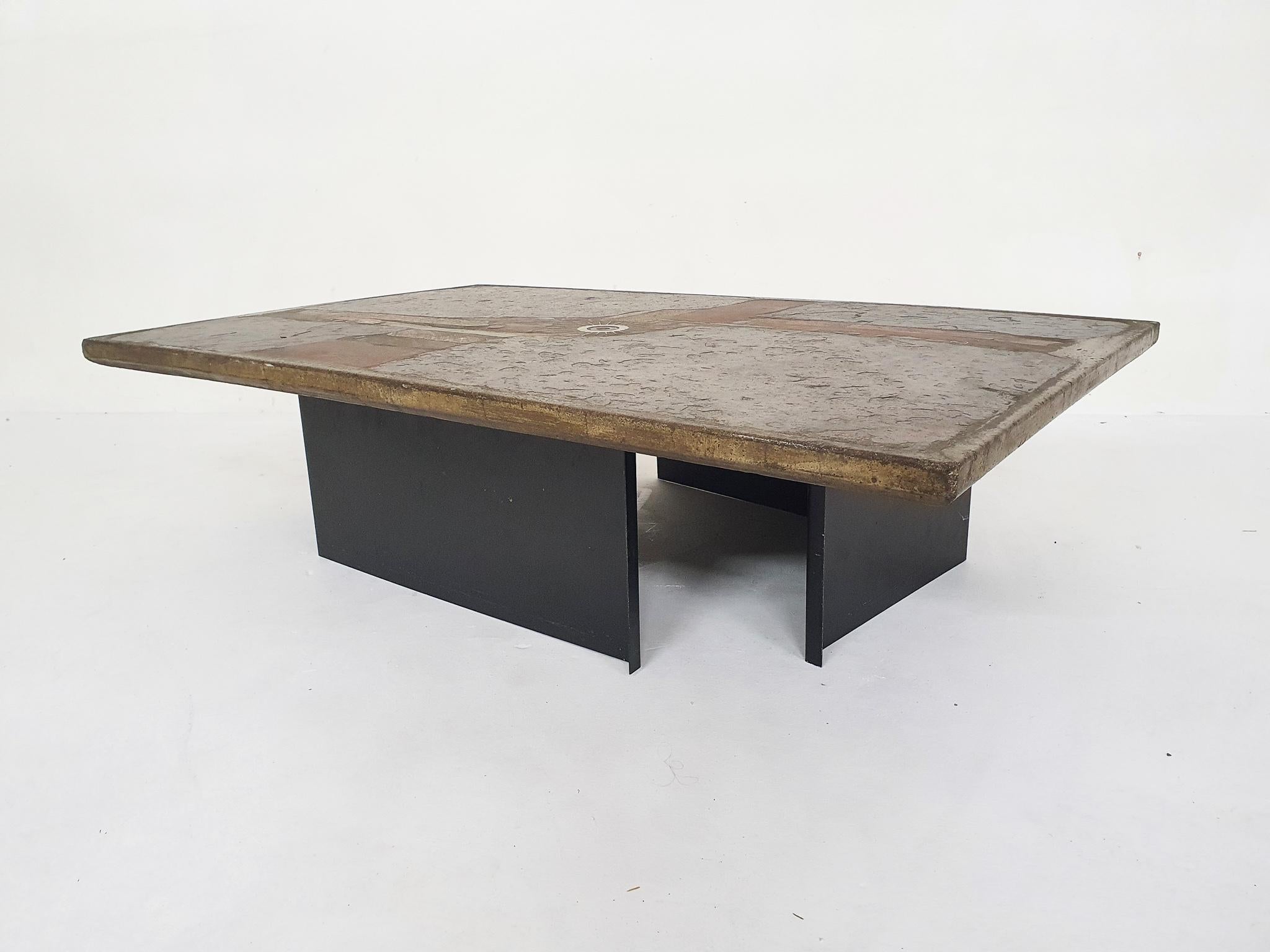 Stone coffee table on two L-shaped metal plates. Desiged and signed by artist Paul Kingma.

Paul Kingma, born in 1931, was a Dutch Sculptor and mosaic artist. In his early years he studied art in Arnhem and became a teacher at the State Academy of