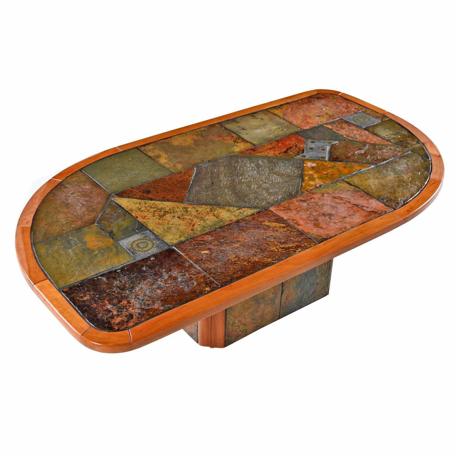 Made in South Africa, this bold and exotic coffee table succeeds in combining the right materials and design elements. The Brutalist style layout of multicolored and textured slate is punctuated with a minimal application of copper inlay. All tied
