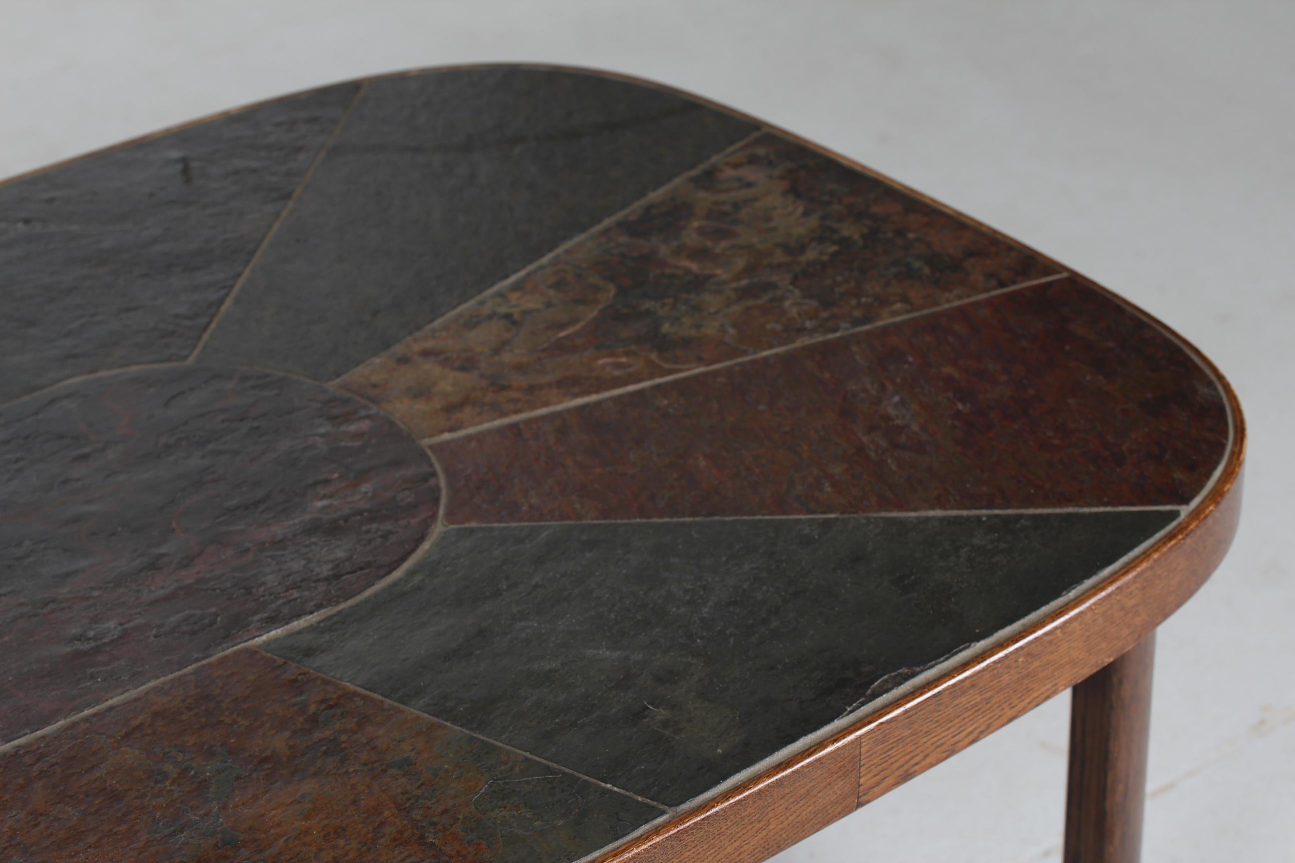 Brutalist Paul Kingma style slate-topped coffee table from the 1980s. 
The frame is made of dark stained oak with a table top of inlaid large pieces of dark coloured slate forms in a pattern

Length 140 cm
Width 80 cm
Height 53 cm

The table