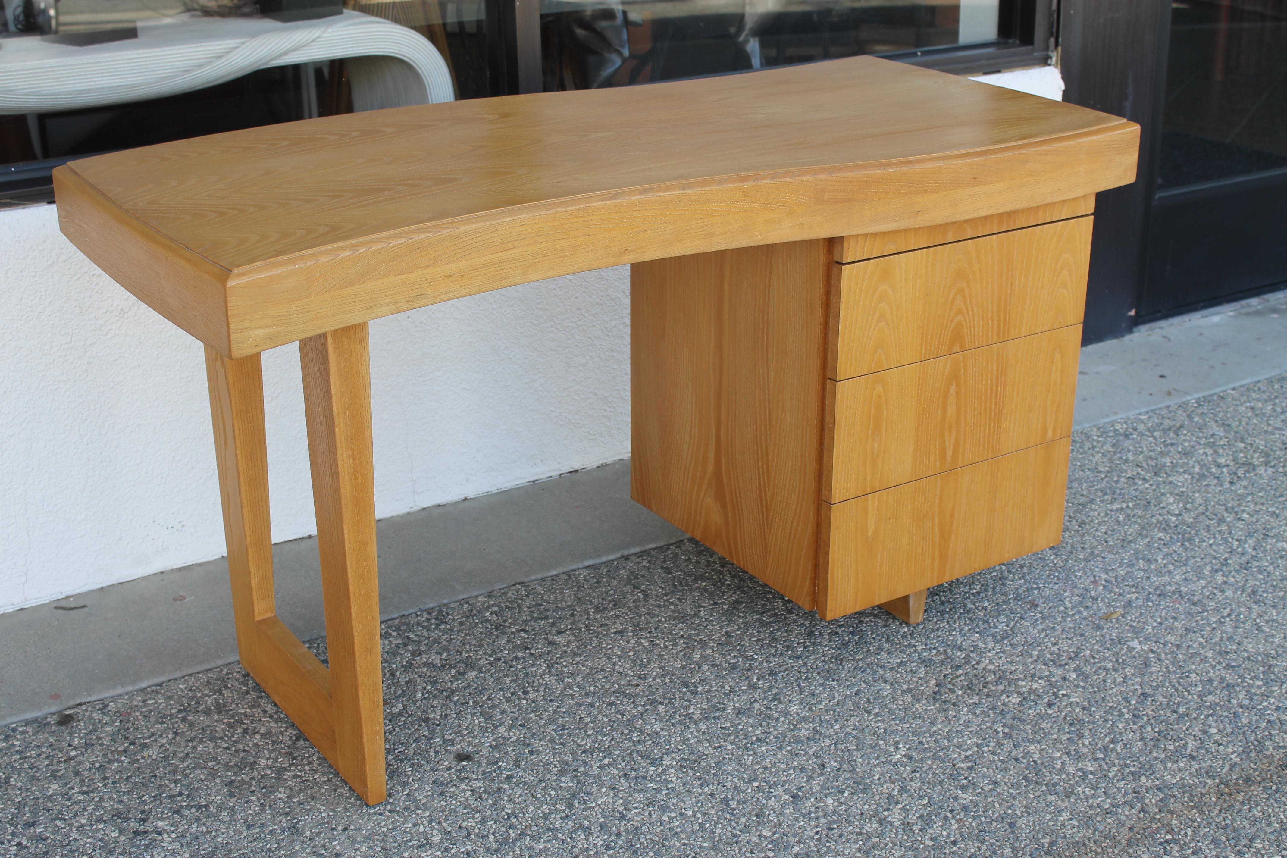 Desk by Paul Laszlo for Brown Saltman, California. Wood is silver elm. Desk measures 53.5” wide, 26” deep and 29.5” high. Desk has been professionally refinished.  Table knee clearance is 26