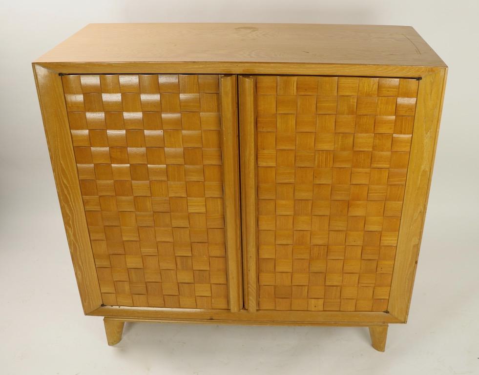 Chic two door cabinet designed by Paul Laszlo for Brown Saltman of California. This piece has the signature weave pattern fronts by Lazslo, and it retains the original Brown Saltman decal. Originally designed to house audio equipment, this equipment