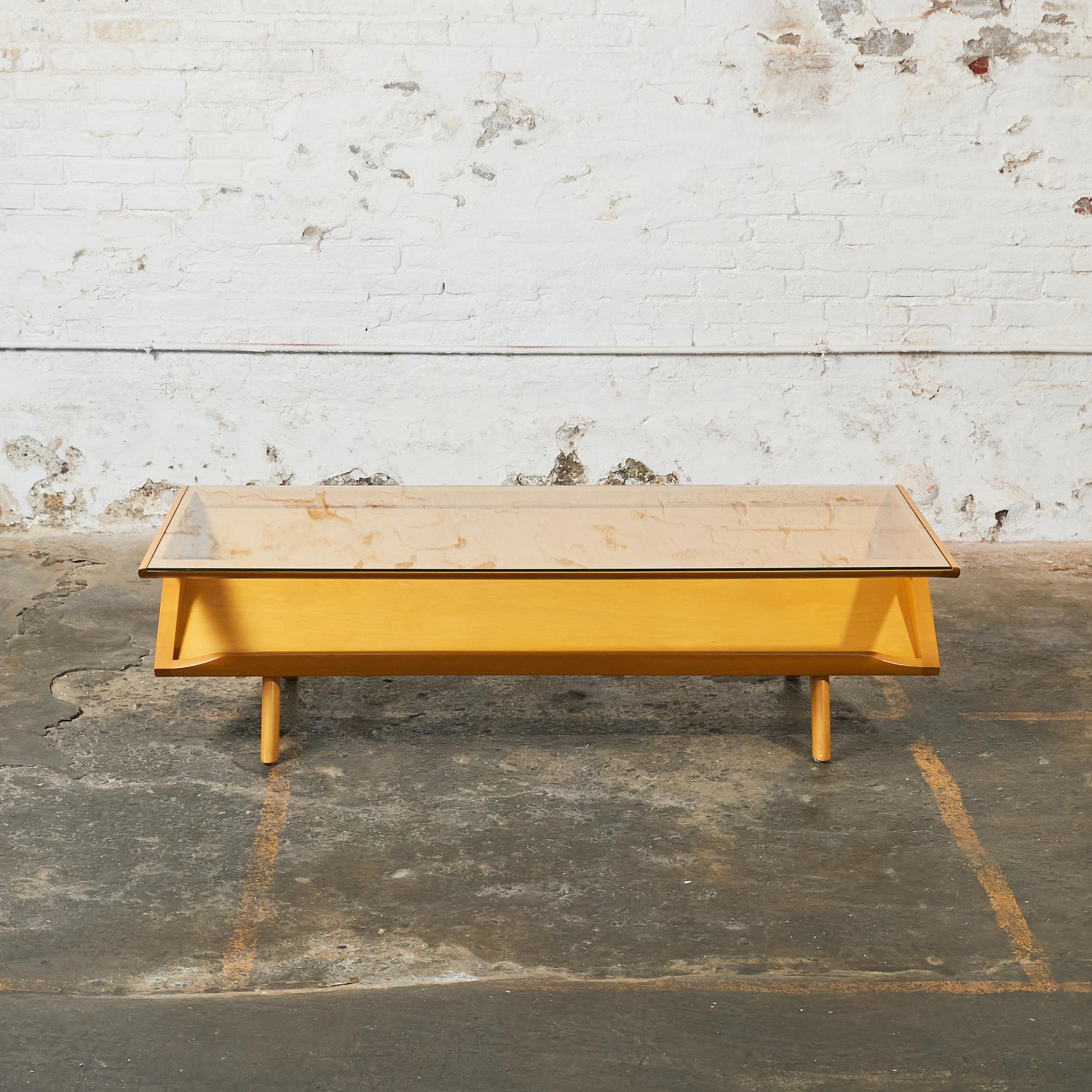 Long rectangular midcentury coffee table. The top frame holds a clear glass insert to see through an angled lower display shelf.
A Classic design by Paul Laszlo for the prominent California design company Brown Saltman.