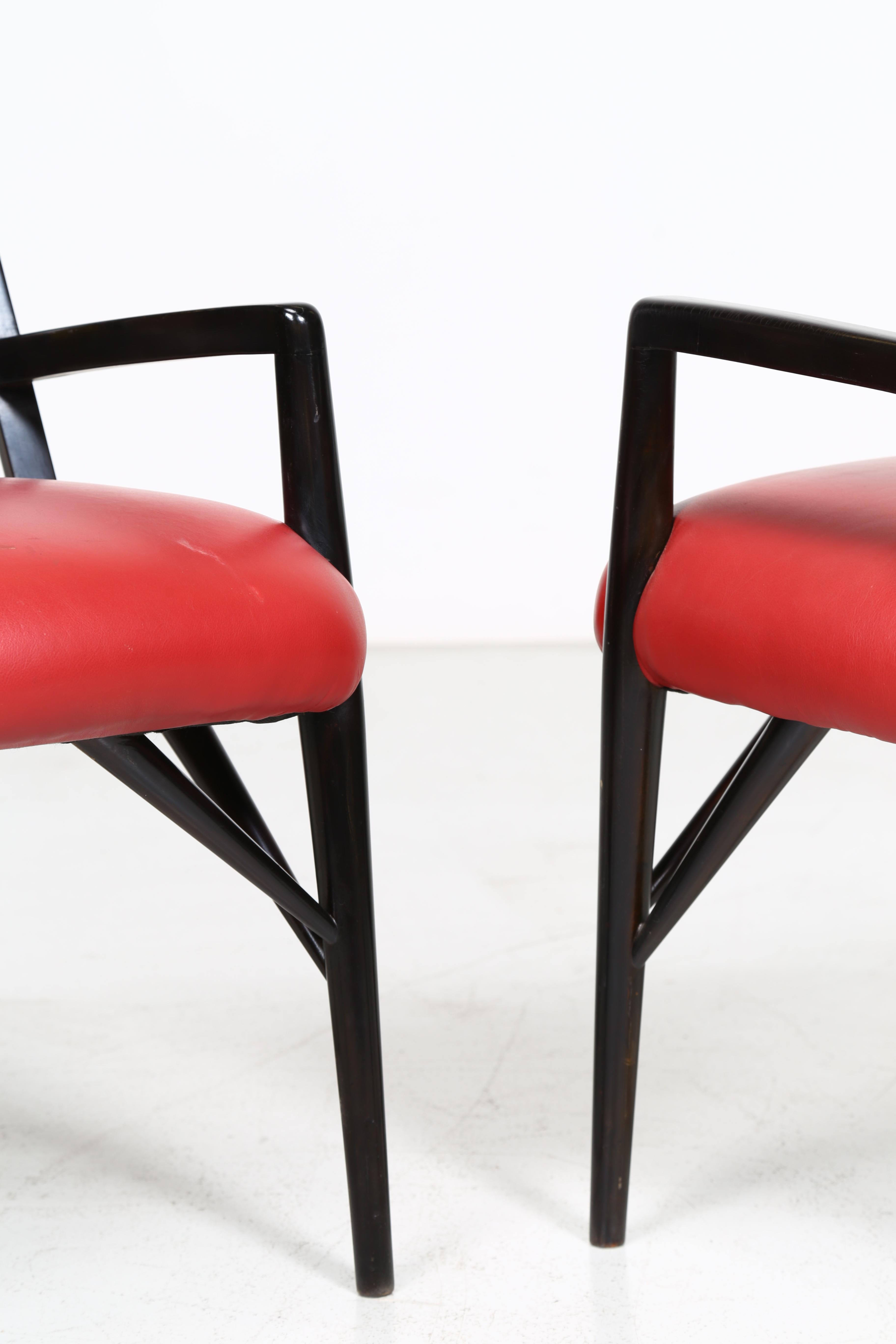 Finished in black lacquered wood with spindle backs, open arms, and architectural supports. Red upholstered seats. *Similar chairs were used in the interior of the Brentwood Country Club, as well as in the interiors of Mr. and Mrs. Fausto M. Ricci,
