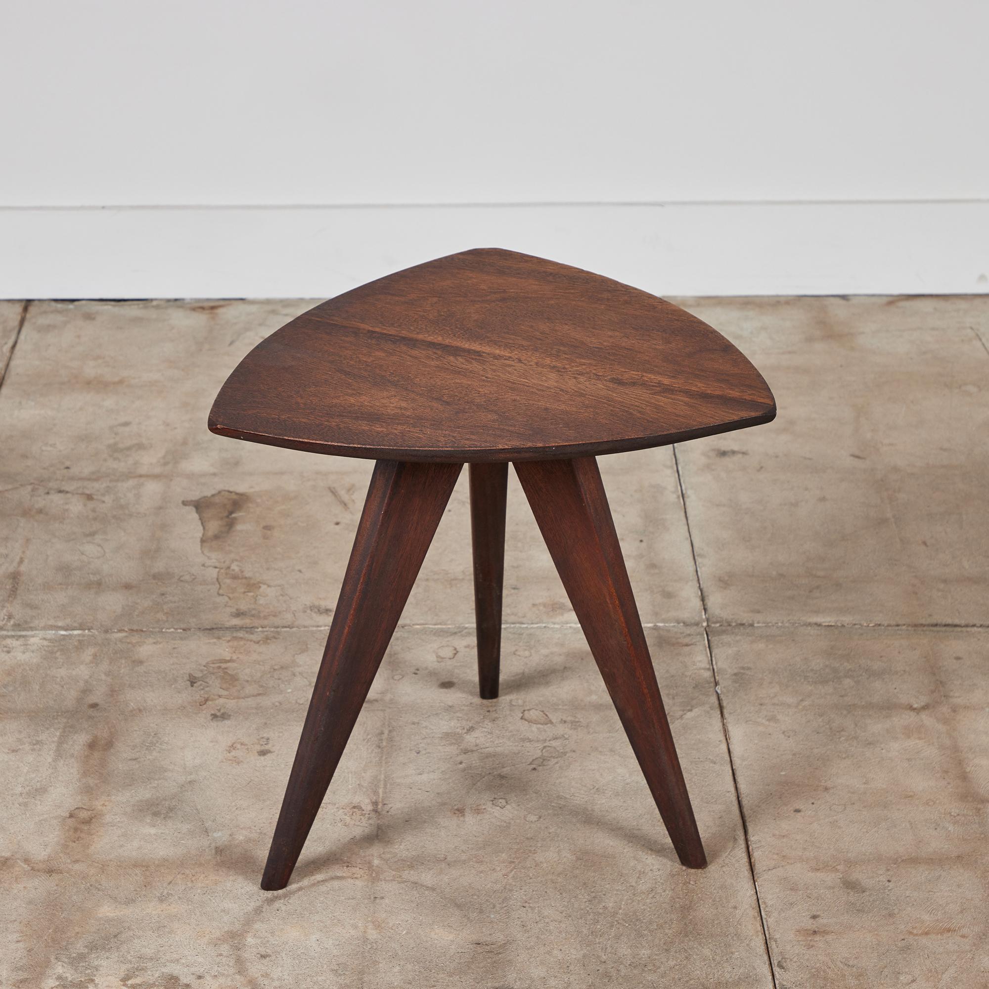 Side table by Paul Laszlo for Glenn of California, c.1950s. The table features an oiled mahogany triangular table top and base. The table sits atop three tapered angled legs.

Dimensions
20