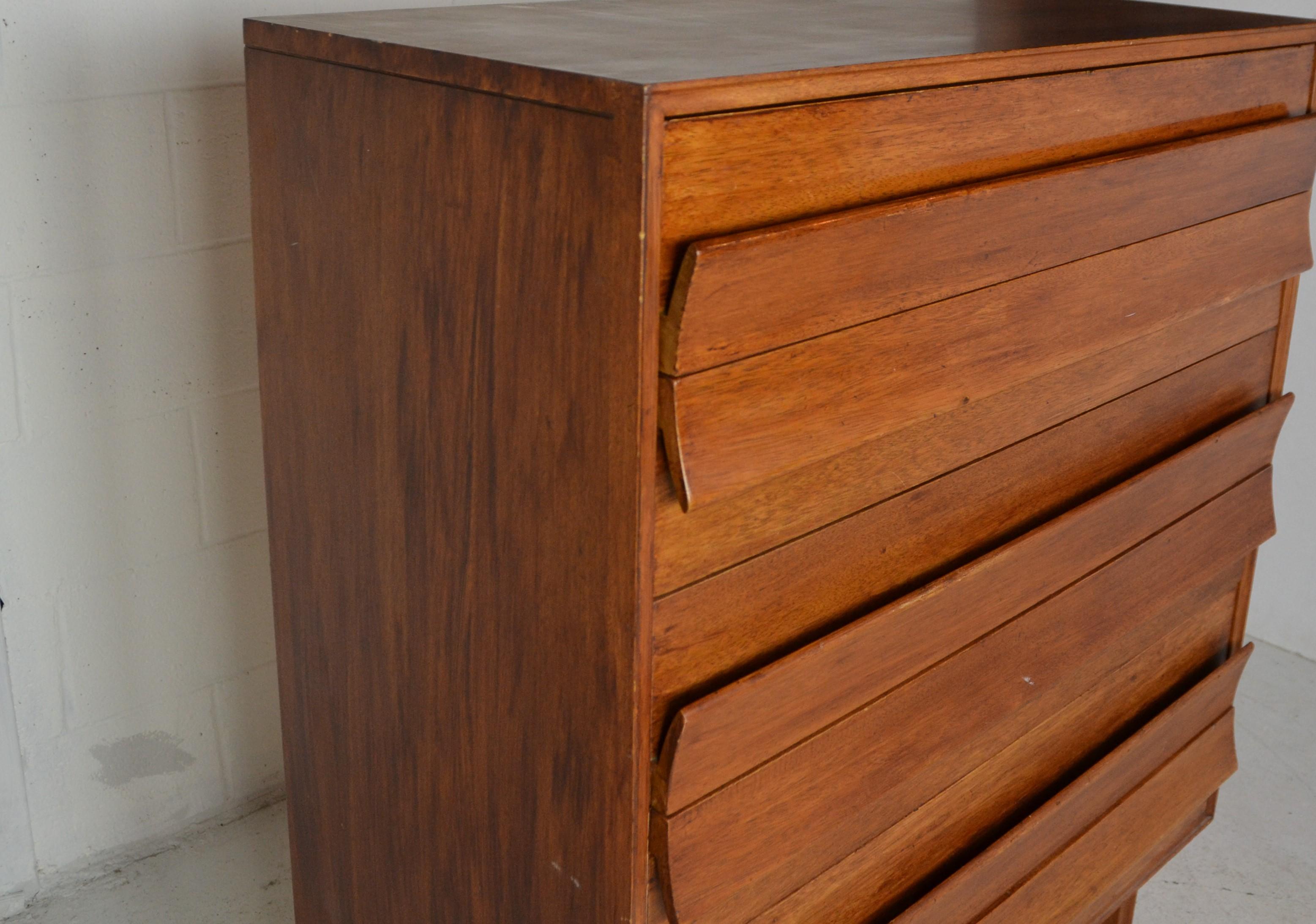 A midcentury chest of drawers designed by Paul Laszlo for Brown Saltman and manufactured in the United States, circa 1950s. Mahogany frame with a geometric base. Unique sculpted fin-like pulls on the six dovetailed drawers.
