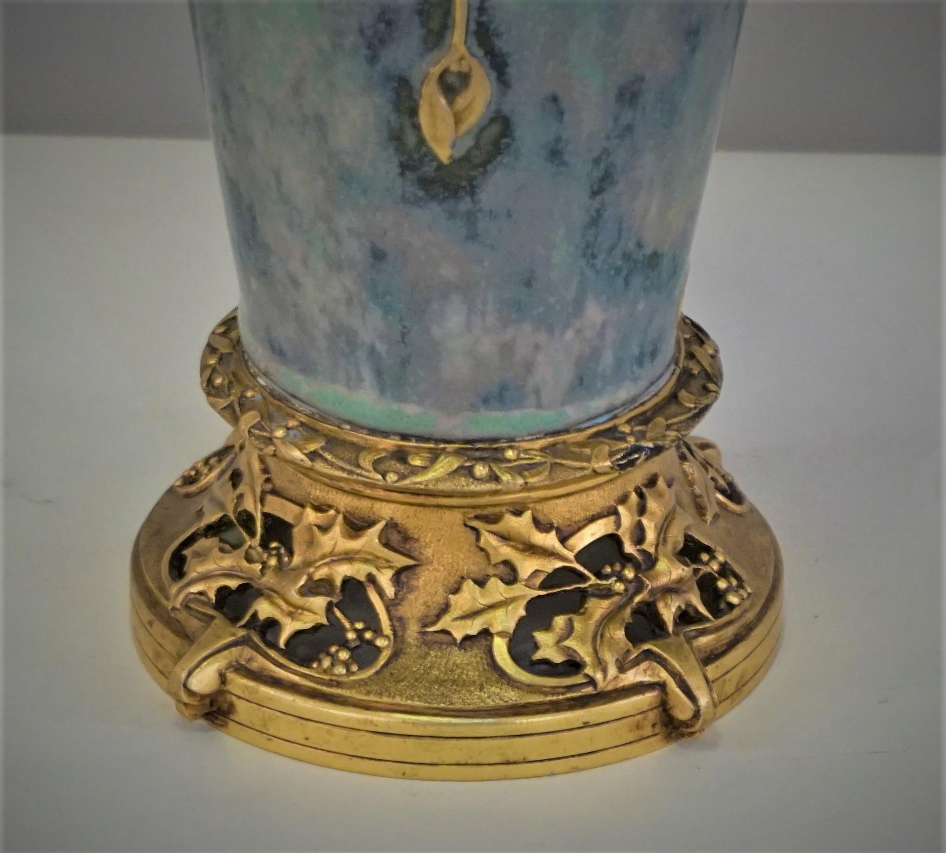 Paul Louchet Vase with gilt-bronze base, France, c. 1900, in the Art Nouveau style gold raise faces on multi color gloss background set on an openwork floral base, raised bronze base.