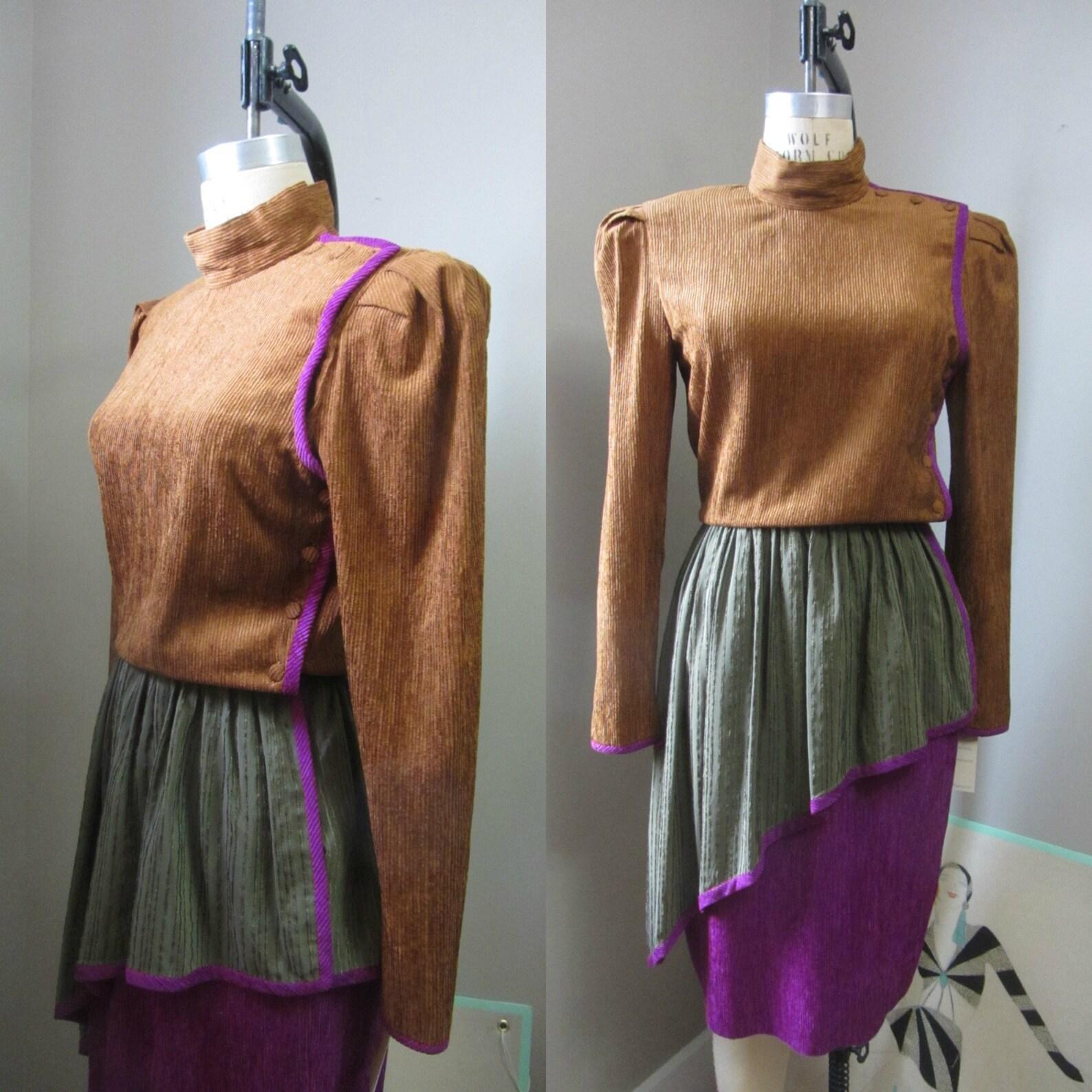 Vestido vintage de seda del diseñador francés Paul-Louis Orrier. Suave seda microplisada en una preciosa combinación de colores única: marrón coñac, verde oliva y morado violeta. Cuello alto. Mangas largas con hombros abullonados (tiene hombreras).