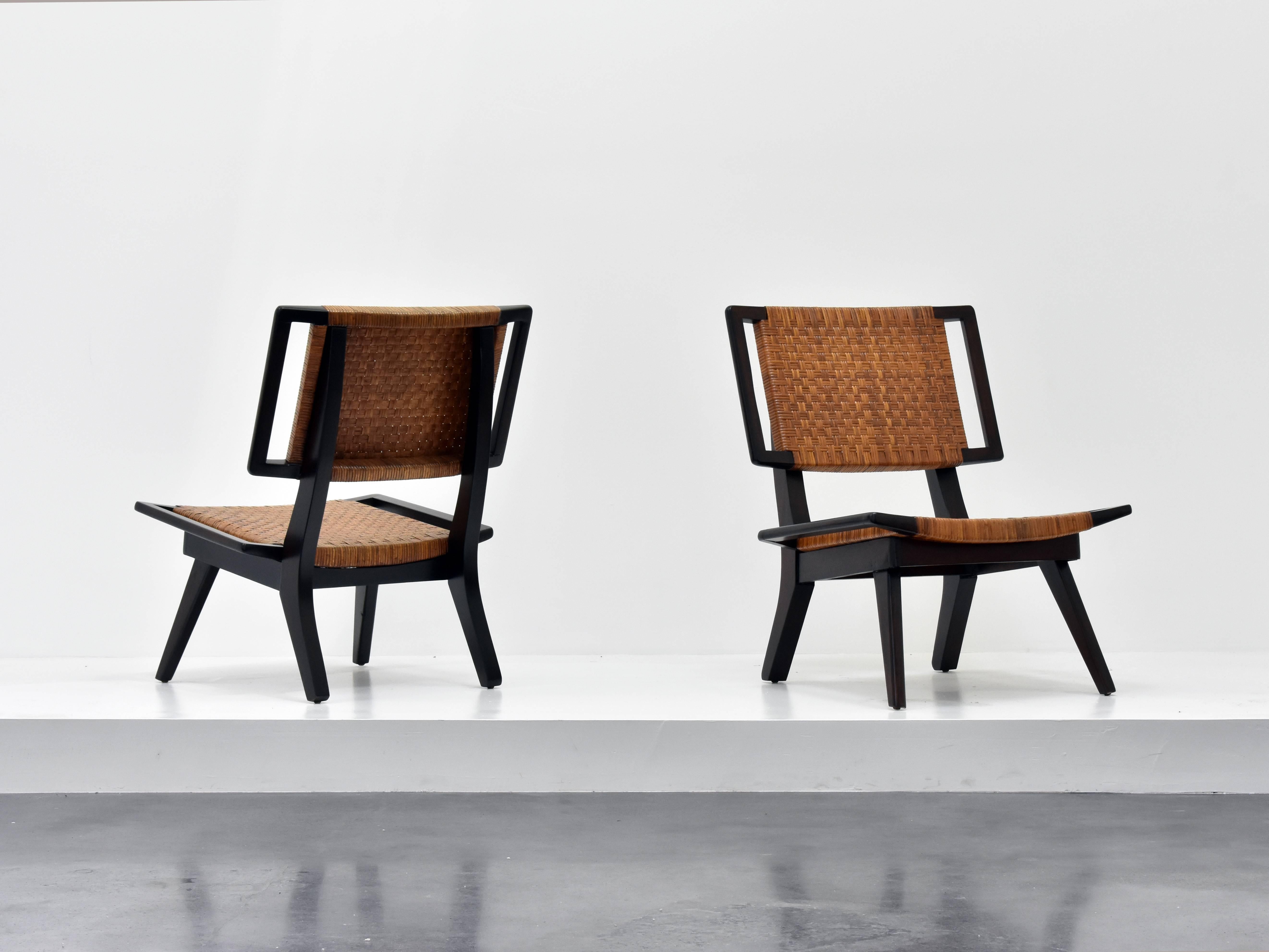 A pair of lounge chairs in the style of Paul László for Glenn of California. Dark stained mahogany and original woven rattan.

Paul László is considered among the most important California-based interior designer/architects of all time. At the