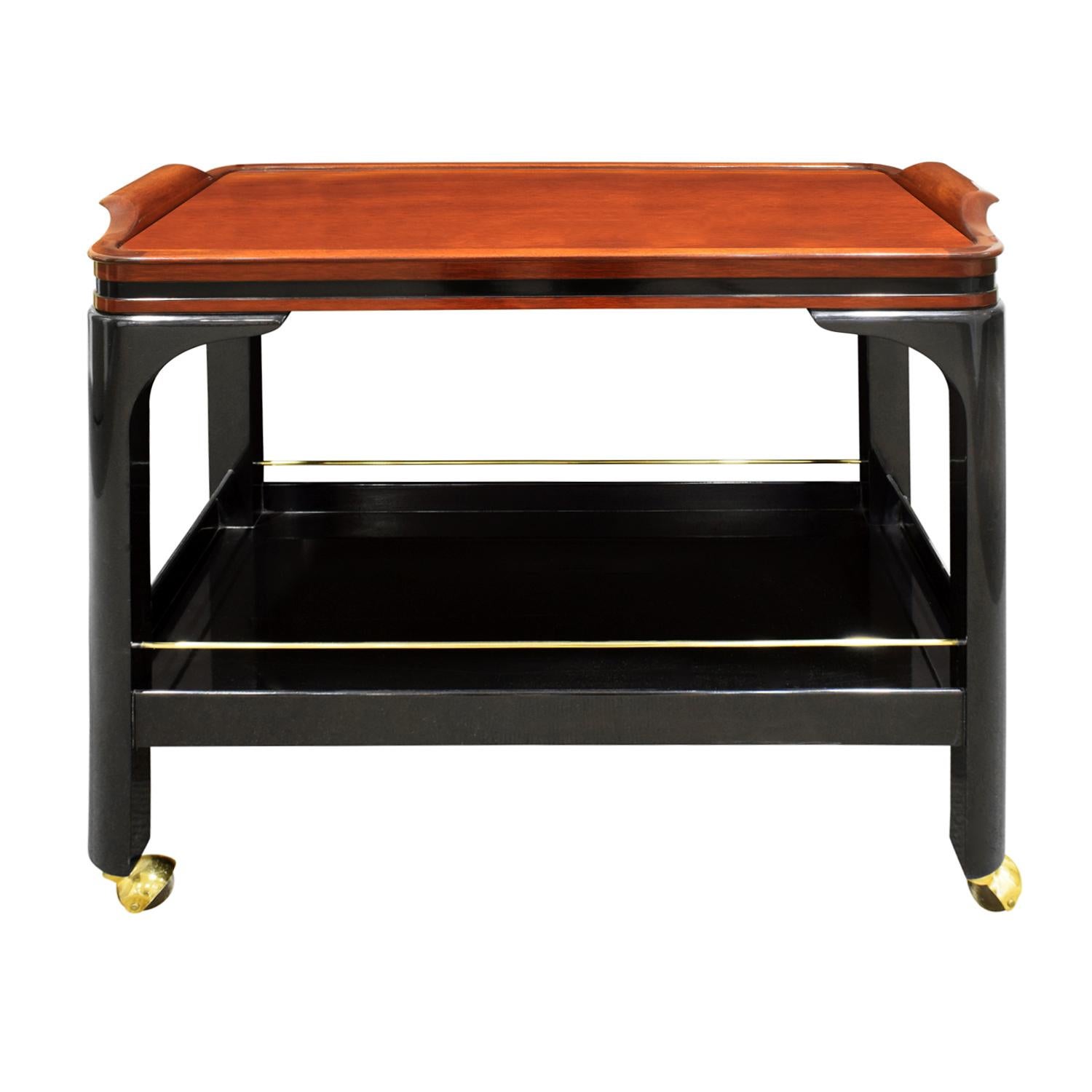Rolling serving/bar cart model no. FM164 with black lacquer base and walnut top with brass accents and castors by Paul M. Jones, American 1960's.  This bar cart is beautifully made and very chic.

Reference:
Paul M Jones catalog published in the