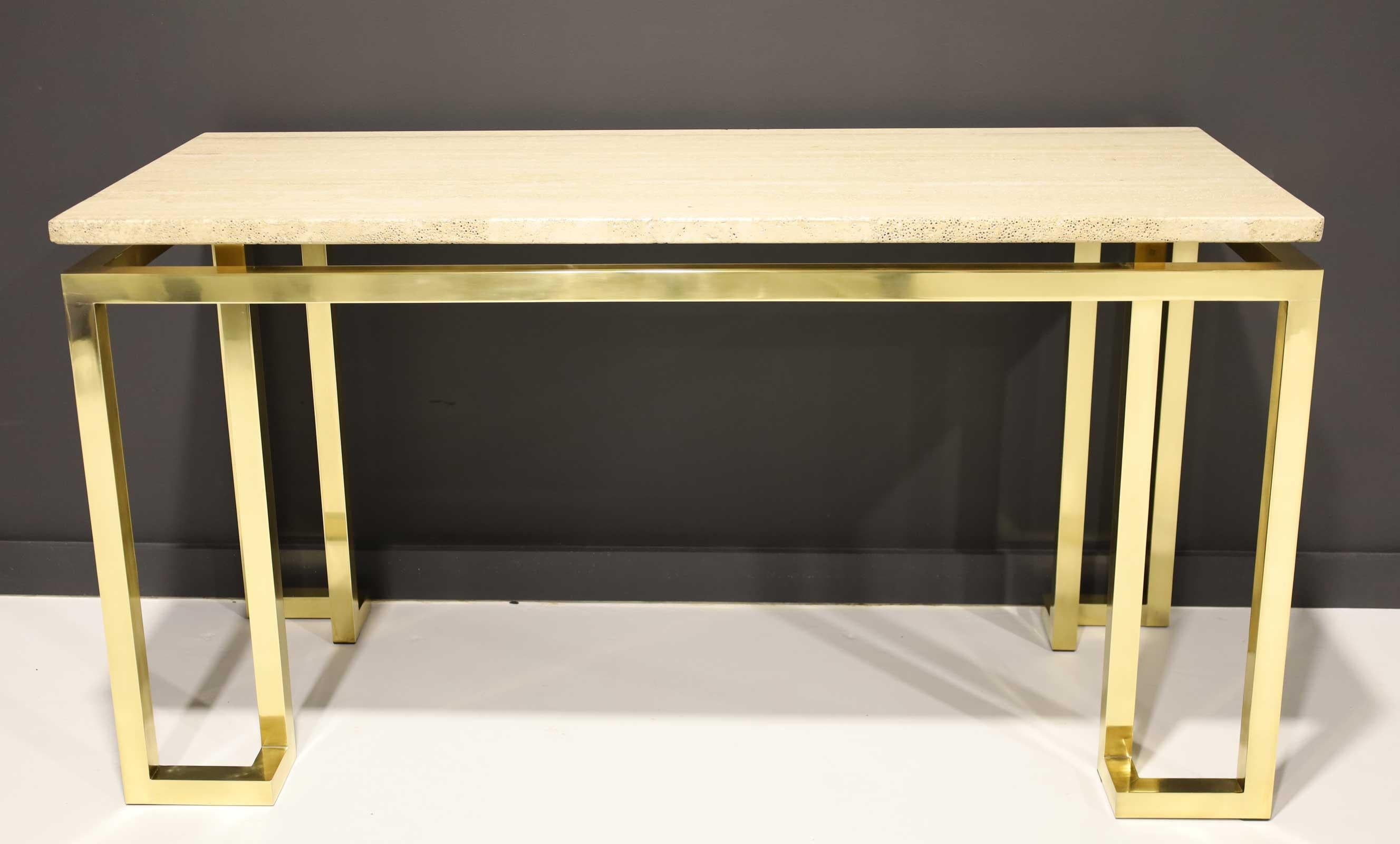 A beautifully crafted console table in solid brass with a floating travertine top. We have polished the brass and sealed it to prevent further tarnishing. The travertine top has beautiful graining.