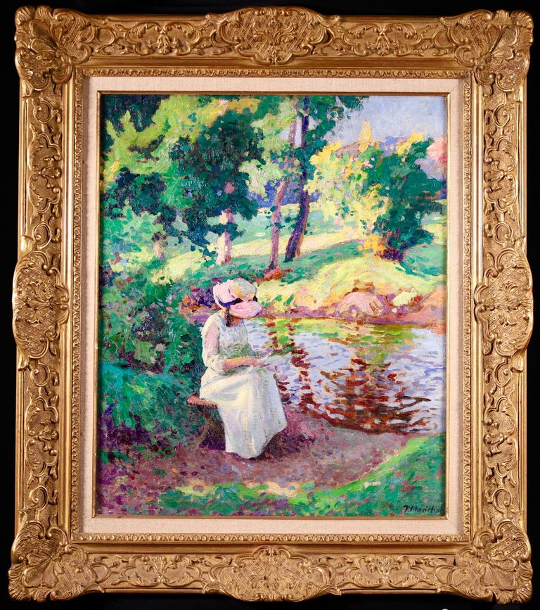 A stunning oil on canvas by French post impressionist painter Paul Madeline depicting a seated young woman in a white dress and pink summer bonnet reading a letter in the shade beside a river. The green grass and trees on the banks of the river