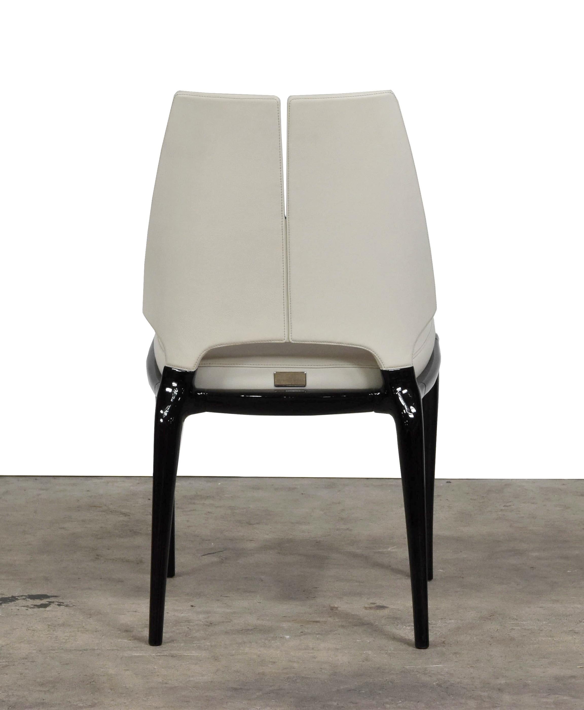 Slender and refined, the Contour chair with armrests brilliantly brings together a sober spirit with
contemporary taste. Made with dark-lacquered wood, it houses the cream colored leather seat
cushion, which matches the seatback upholstery.