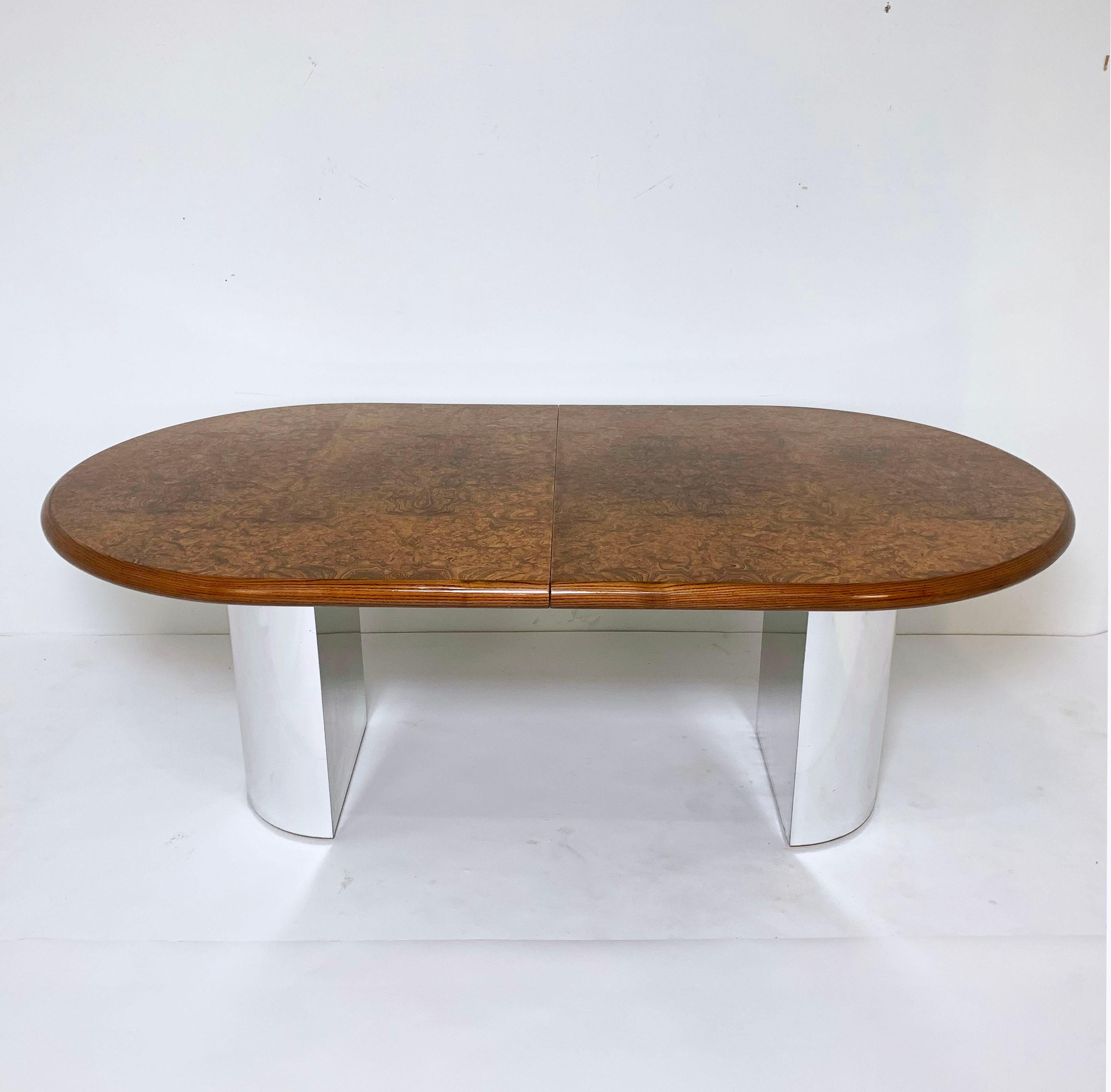 An oval dining table in burl wood and ash with chromed steel demilune pedestals. Designed by Paul Mayen for Intrex Habitat International, circa 1980s, it features a wide bullnose edge similar to many of Karl Springer’s tables of the same period.