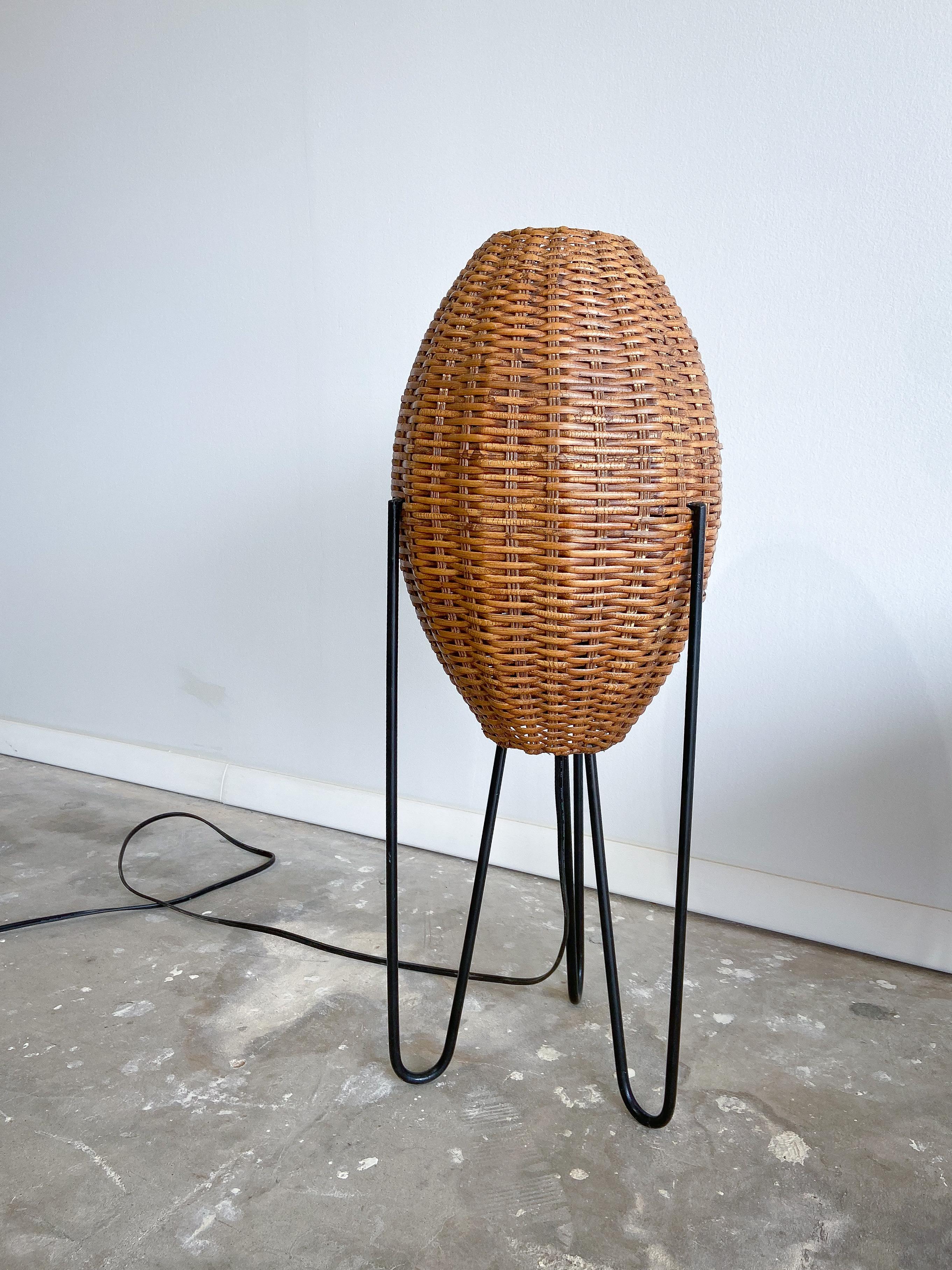 Offered is a unique large scale table lamp by Paul Mayén.

Featuring a handmade wicker shade supported by a formed and enameled steel frame.

When illuminated this lamp gives off a wonderful warm glow. 

This would be a great addition to any