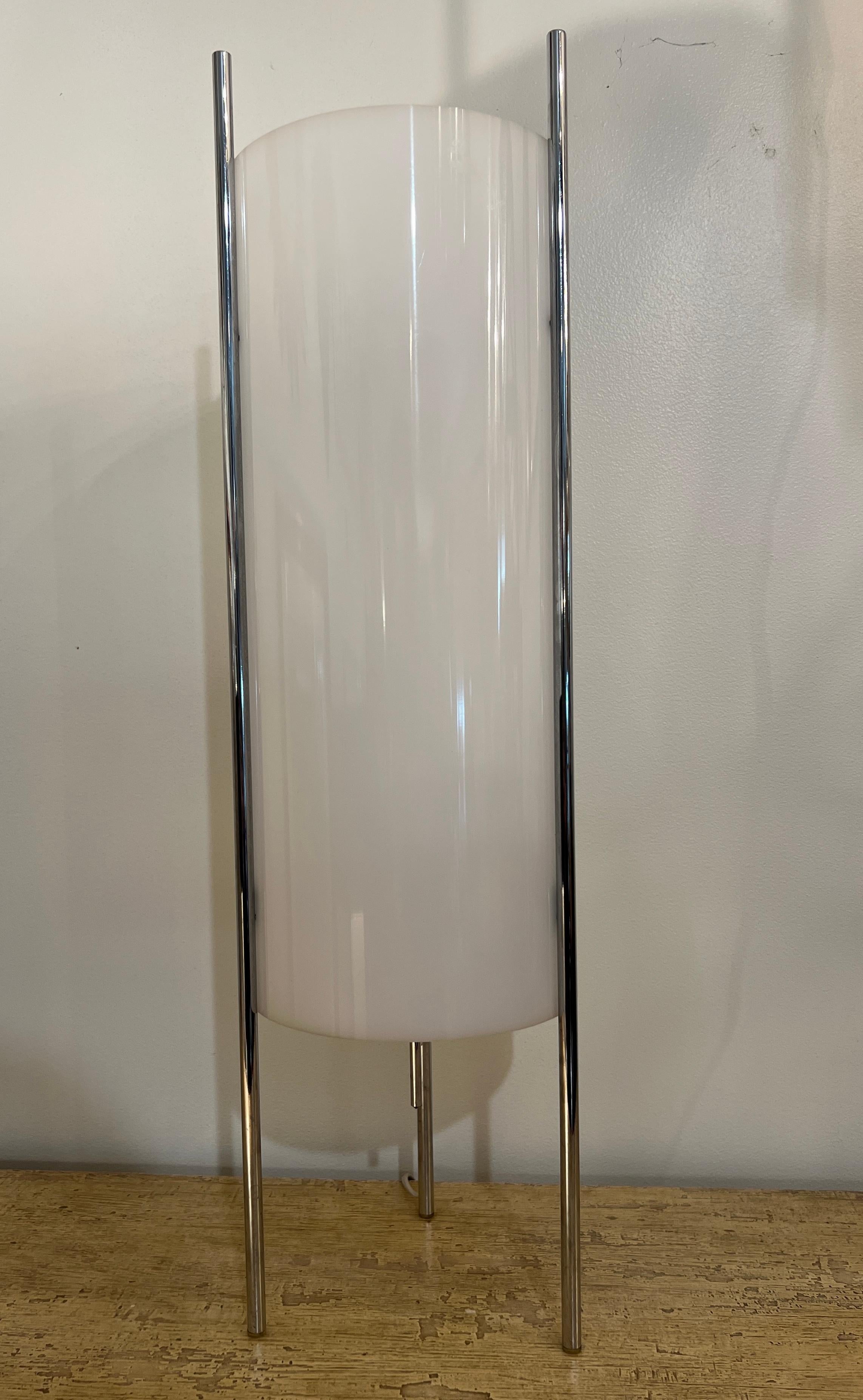 A Hollywood regency-style chrome and acrylic cylinder table lamp inspired by Paul Mayen's 1970's design. It boasts a frosted white acrylic cylinder shade upheld by three chrome metal brackets. 